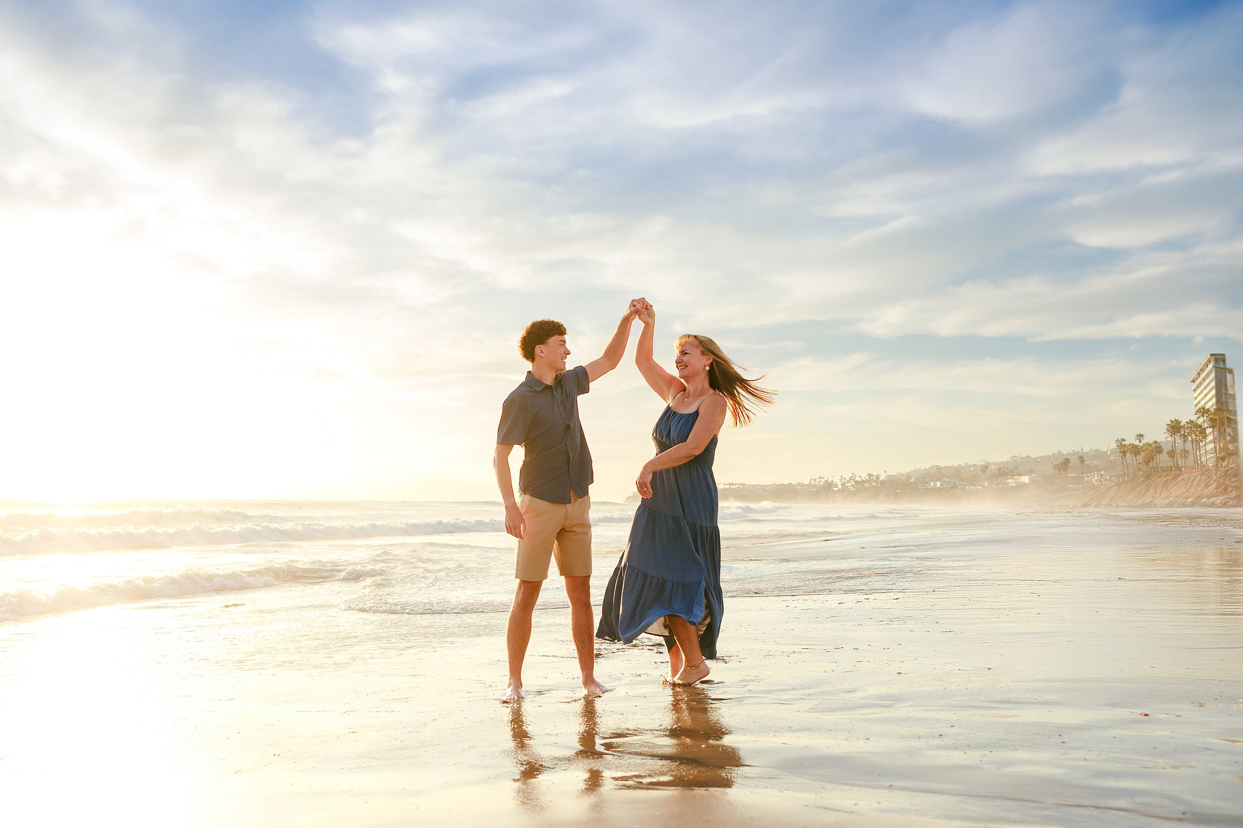 San Diego Beach Family Photos — 18 Young woman and man celebrating with high-five at shoreline