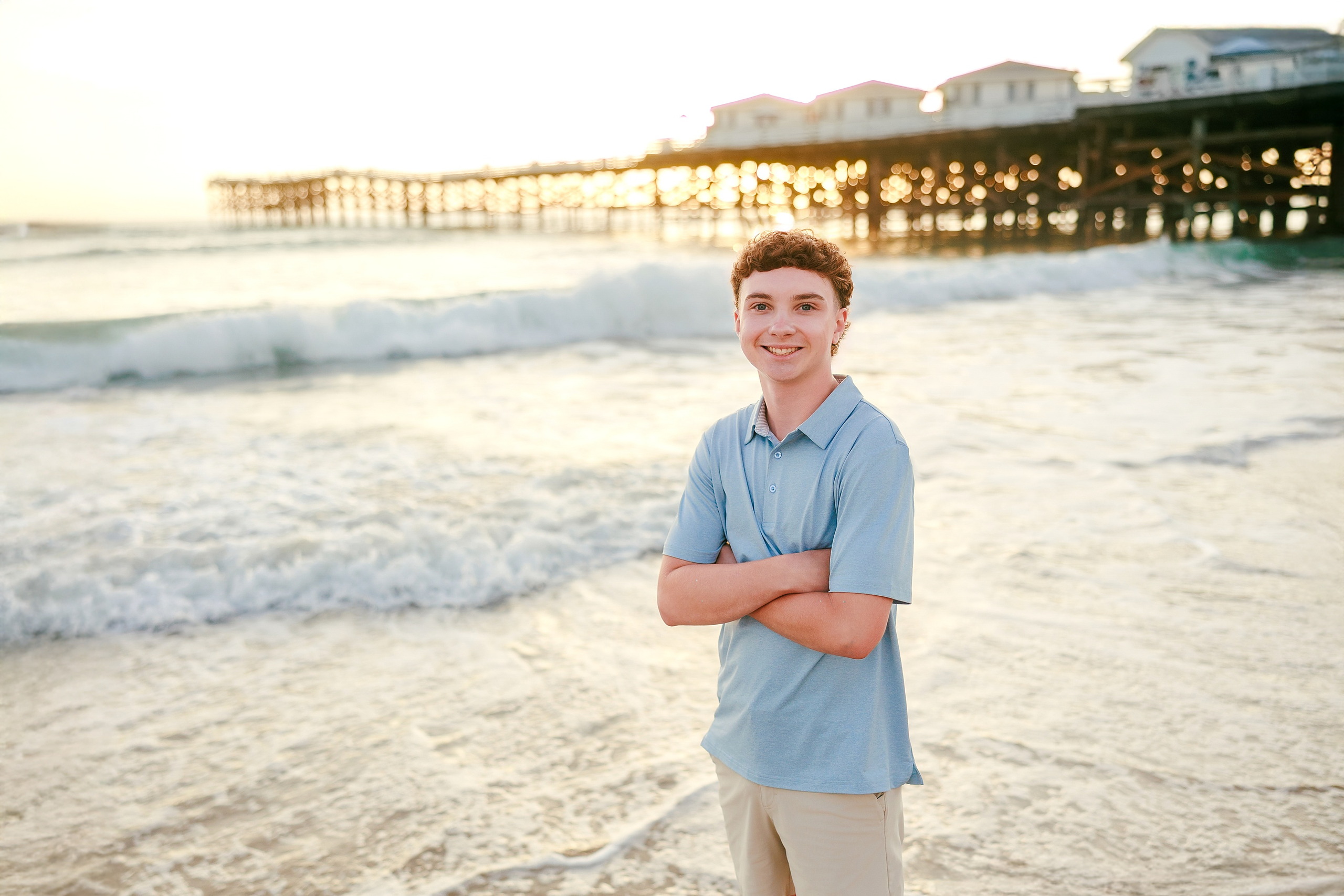 San Diego Beach Family Photos — 24 Teen boy in blue shirt standing on beach with arms crossed