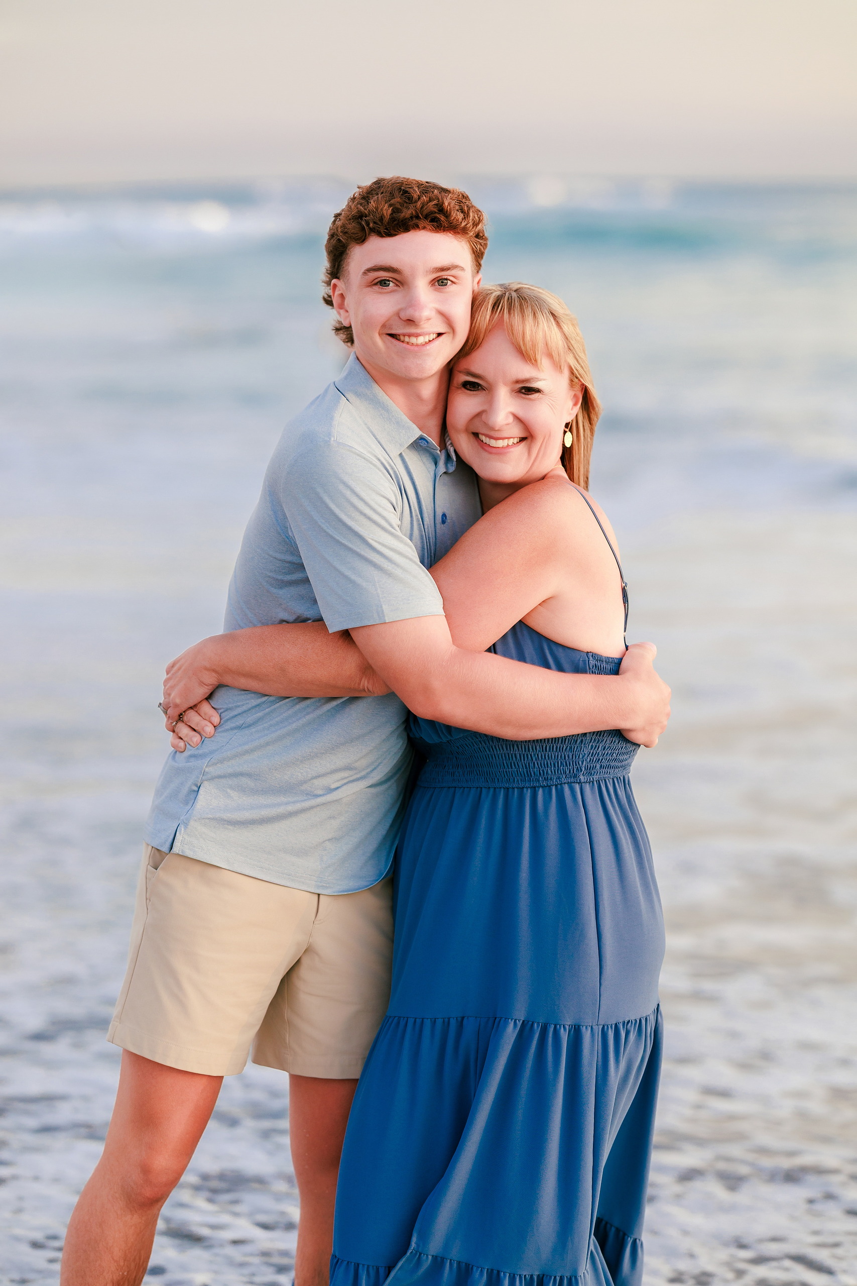 San Diego Beach Family Photos — 37 Teenage boy from behind hugging adult woman affectionately on beach