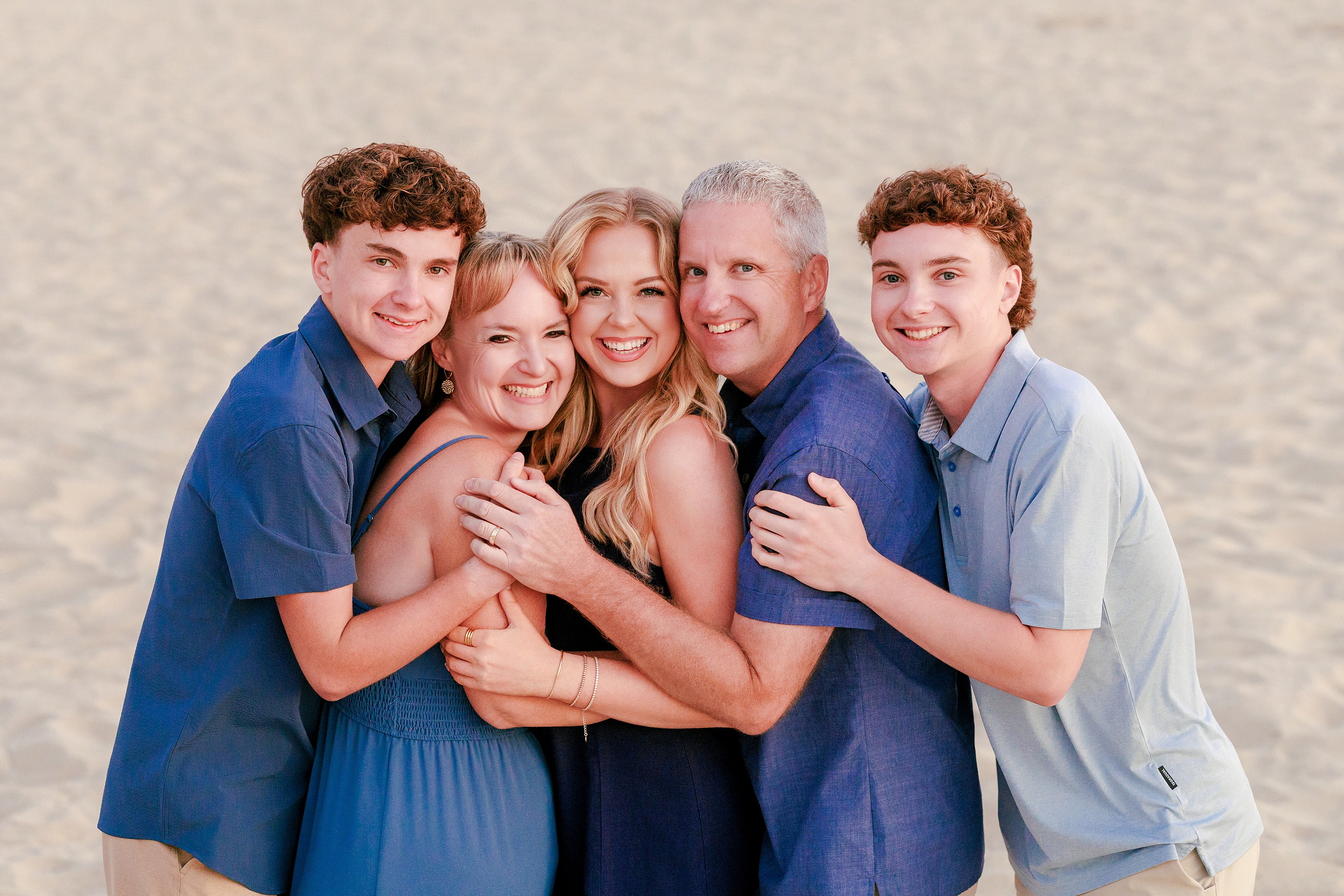 San Diego Beach Family Photos — 41 Family of five gathered together on sand by numbered lifeguard stand