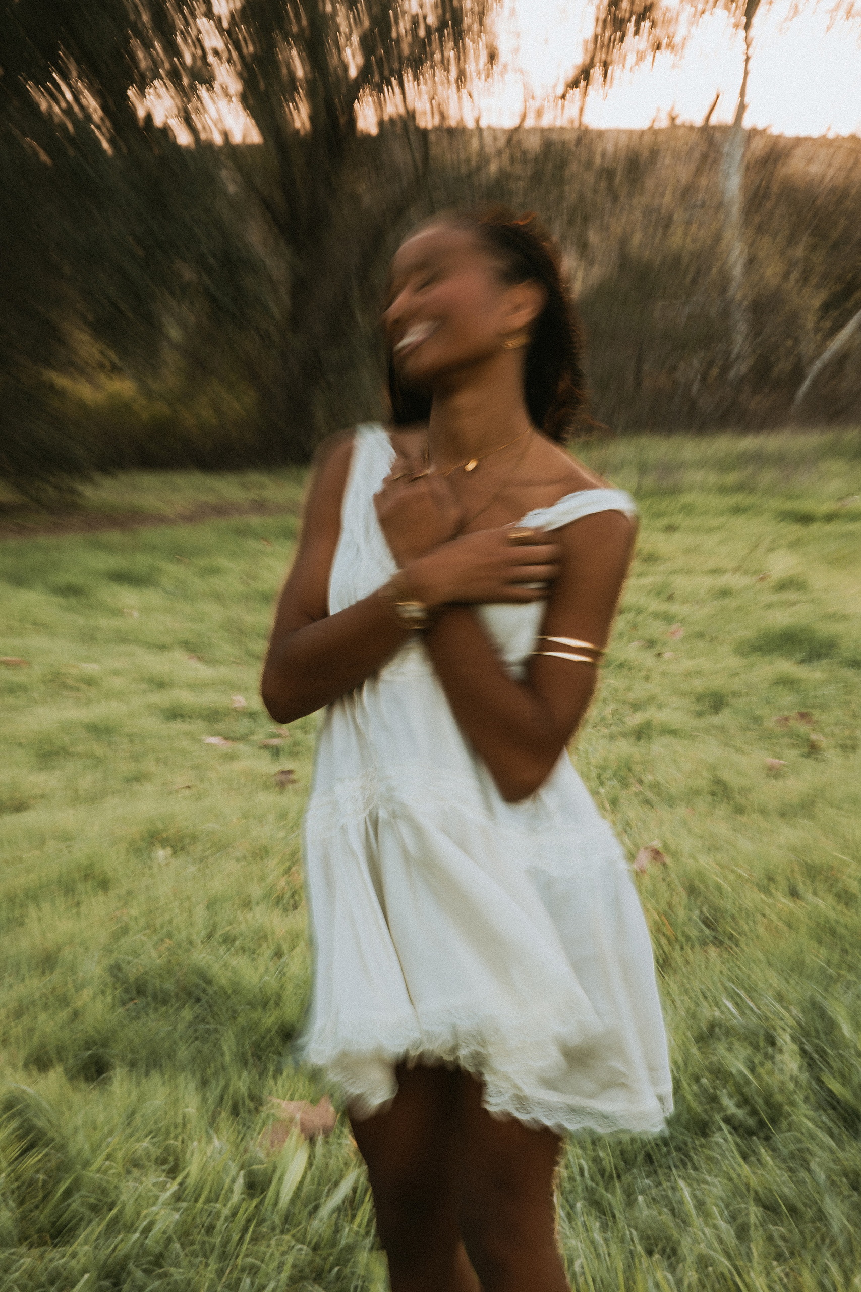 San Diego Senior Photos — 04 Kaelyn in white dress spinning with motion blur through grassy field