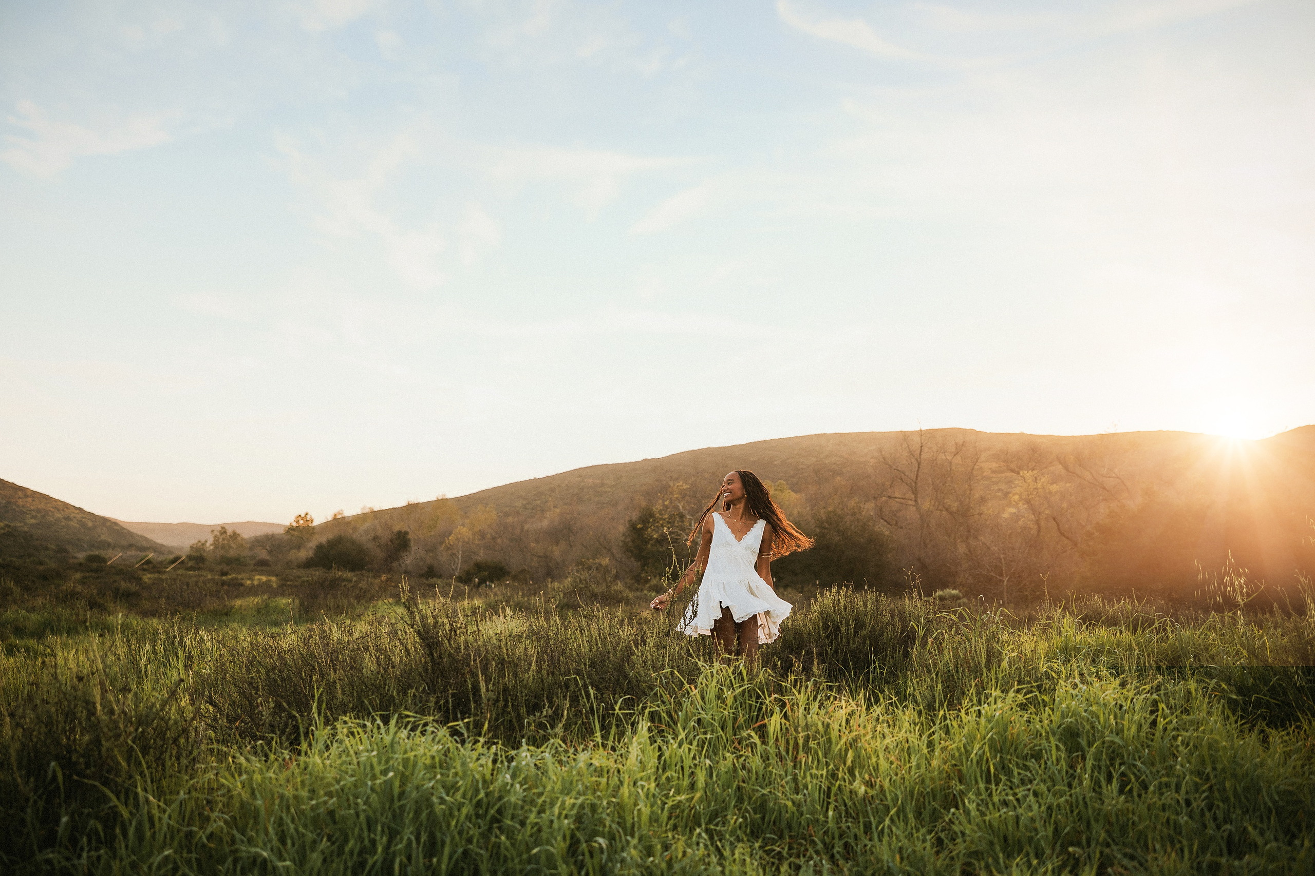 San Diego Senior Photos — 05 Kaelyn in white dress running across hillside at golden hour