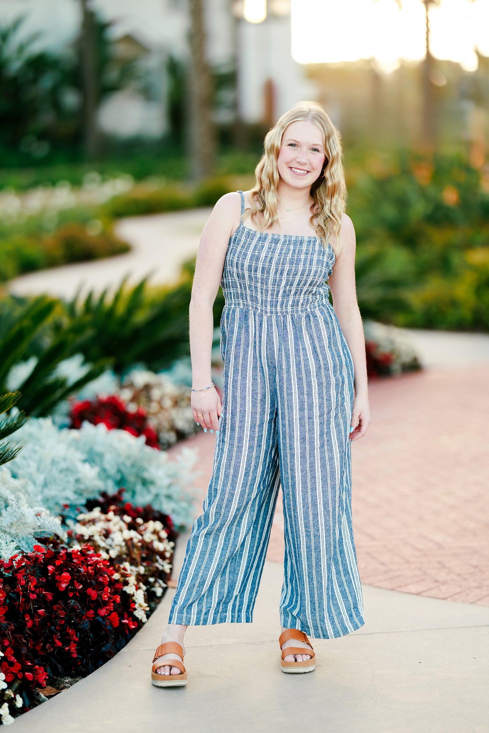 Sisters & Senior Portraits at the Del — 05 Teen standing in white pants and blue striped dress at sunset by Hotel del Coronado