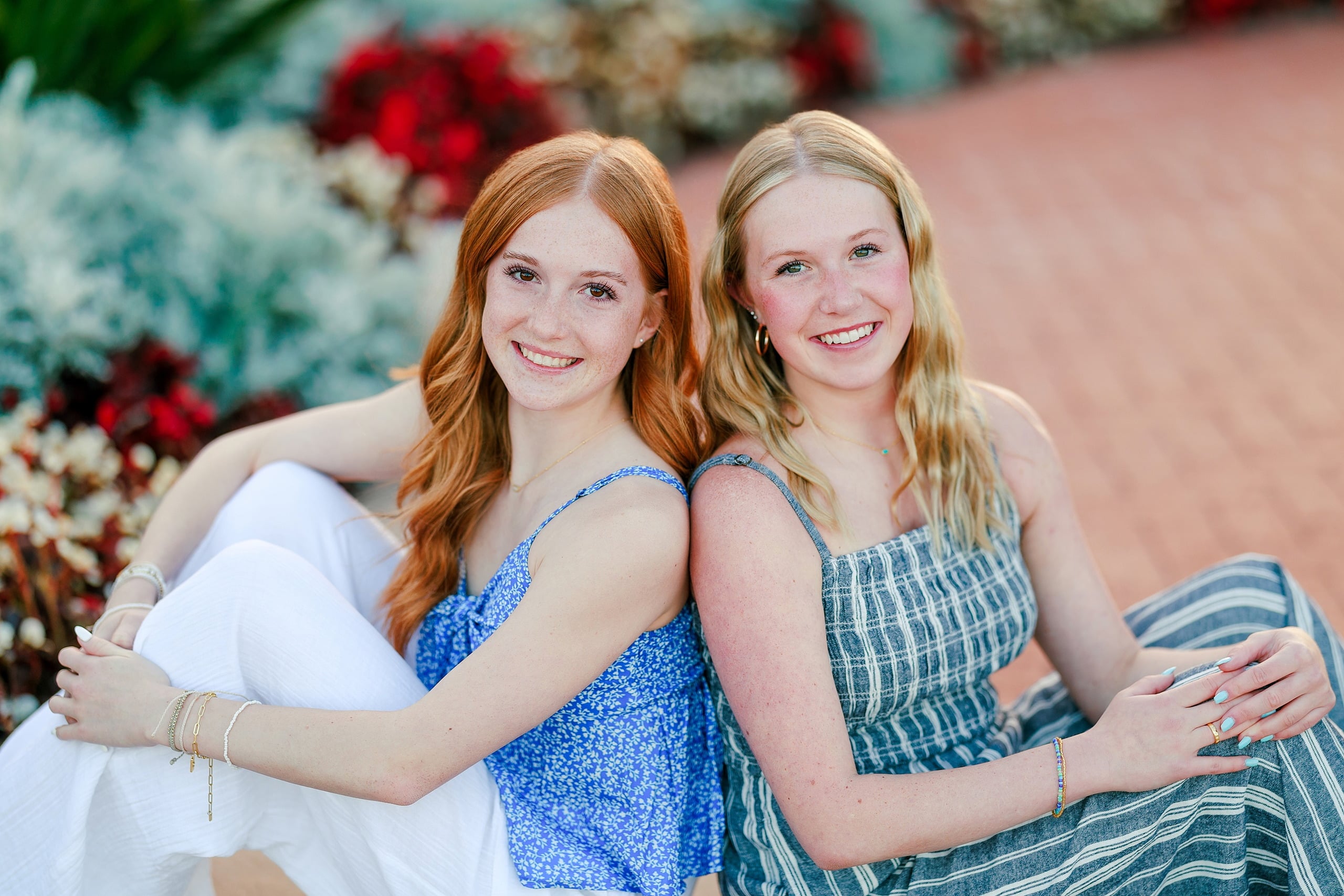 Sisters & Senior Portraits at the Del — 09 Two sisters embracing in the garden with colorful flowers surrounding them