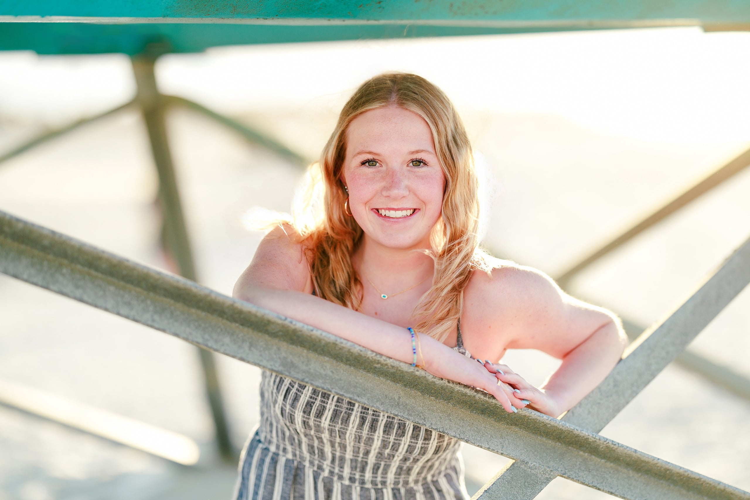 Sisters & Senior Portraits at the Del — 11 Teen in blue top on pier railing with open sky and ocean beyond
