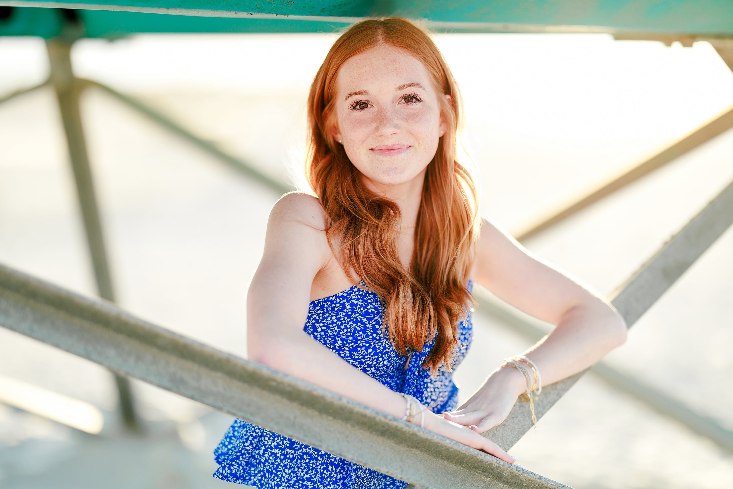 Sisters & Senior Portraits at the Del — 12 Teen in blue floral top posing on pier with soft ocean light