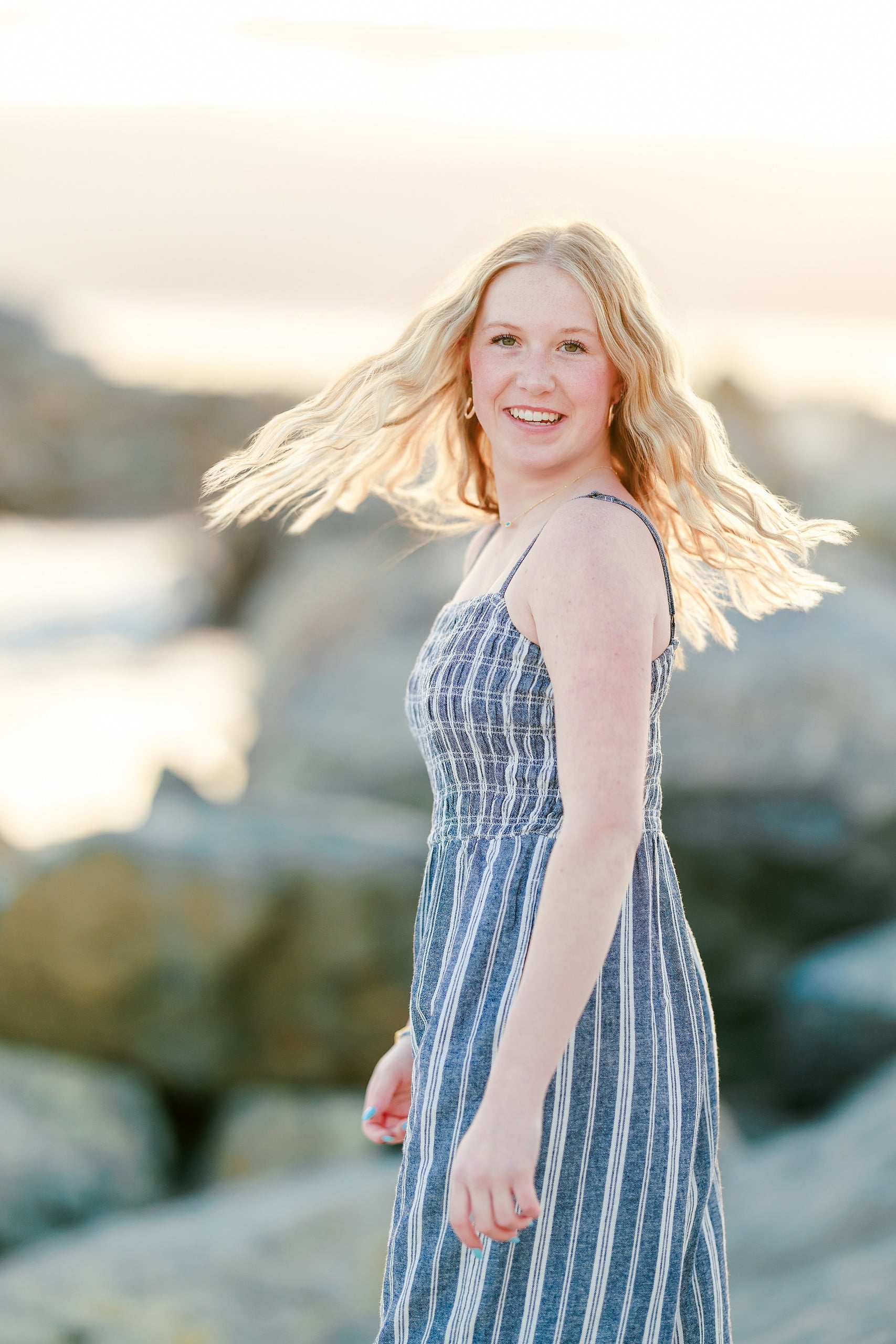 Sisters & Senior Portraits at the Del — 14 Teen spinning with long hair flowing, wearing striped dress at ocean sunset