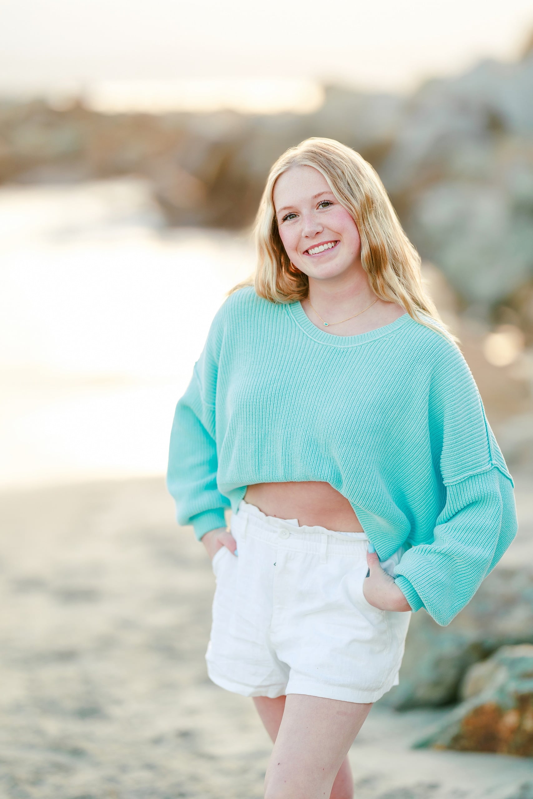 Sisters & Senior Portraits at the Del — 18 Teen in turquoise top and white shorts walking through shallow water on beach