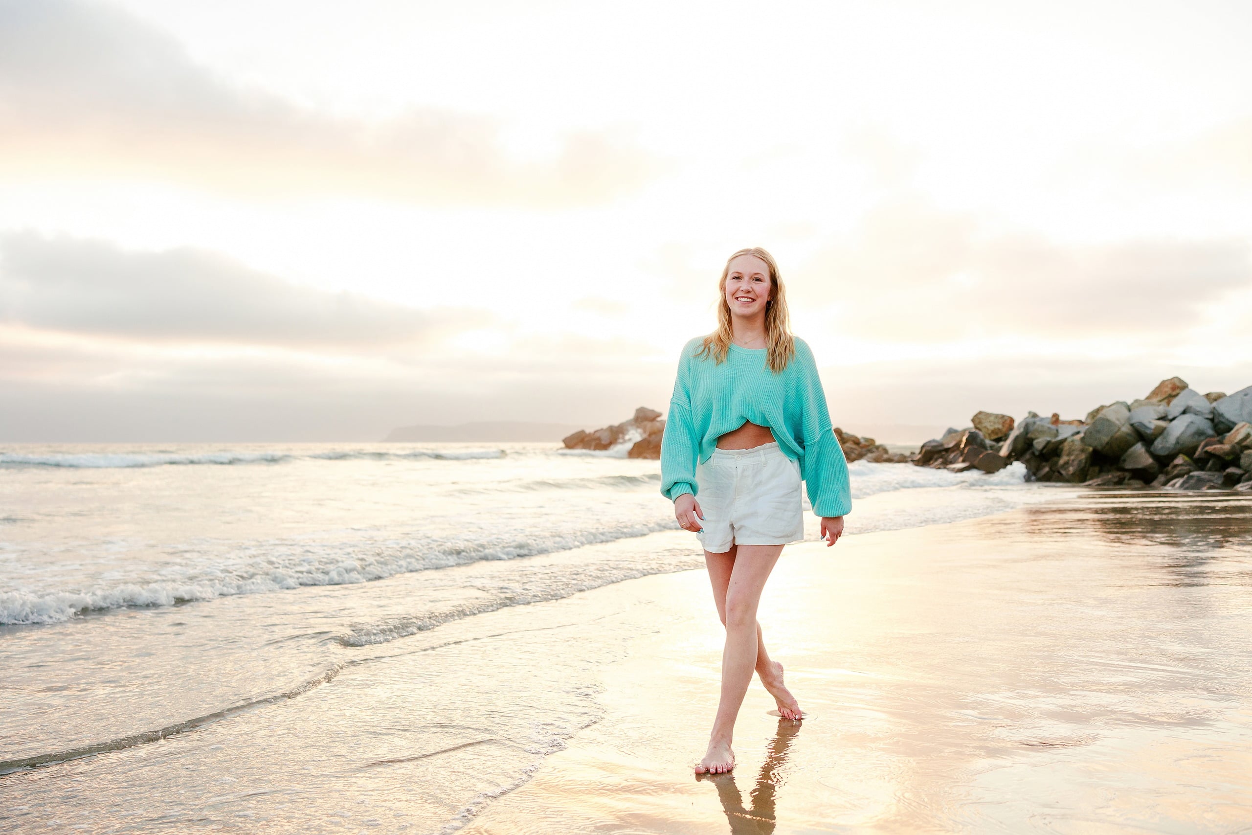 Sisters & Senior Portraits at the Del — 20 Teen running through shallow water in green romper on the beach