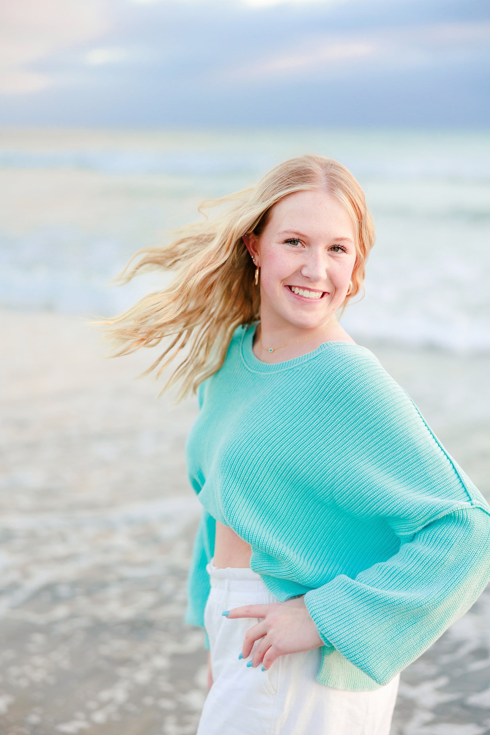 Sisters & Senior Portraits at the Del — 24 Teen in green dress leaning against large boulder on rocky beach area