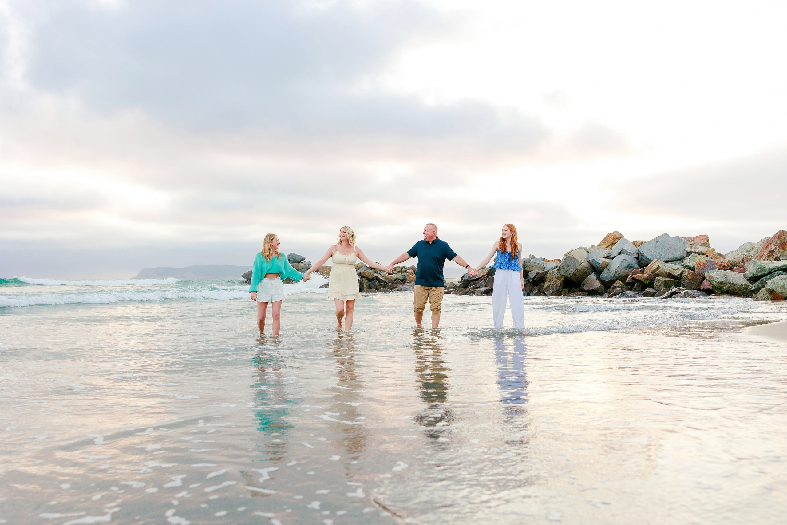 Sisters & Senior Portraits at the Del — 30 Two sisters standing back-to-back in shallow water facing the open ocean