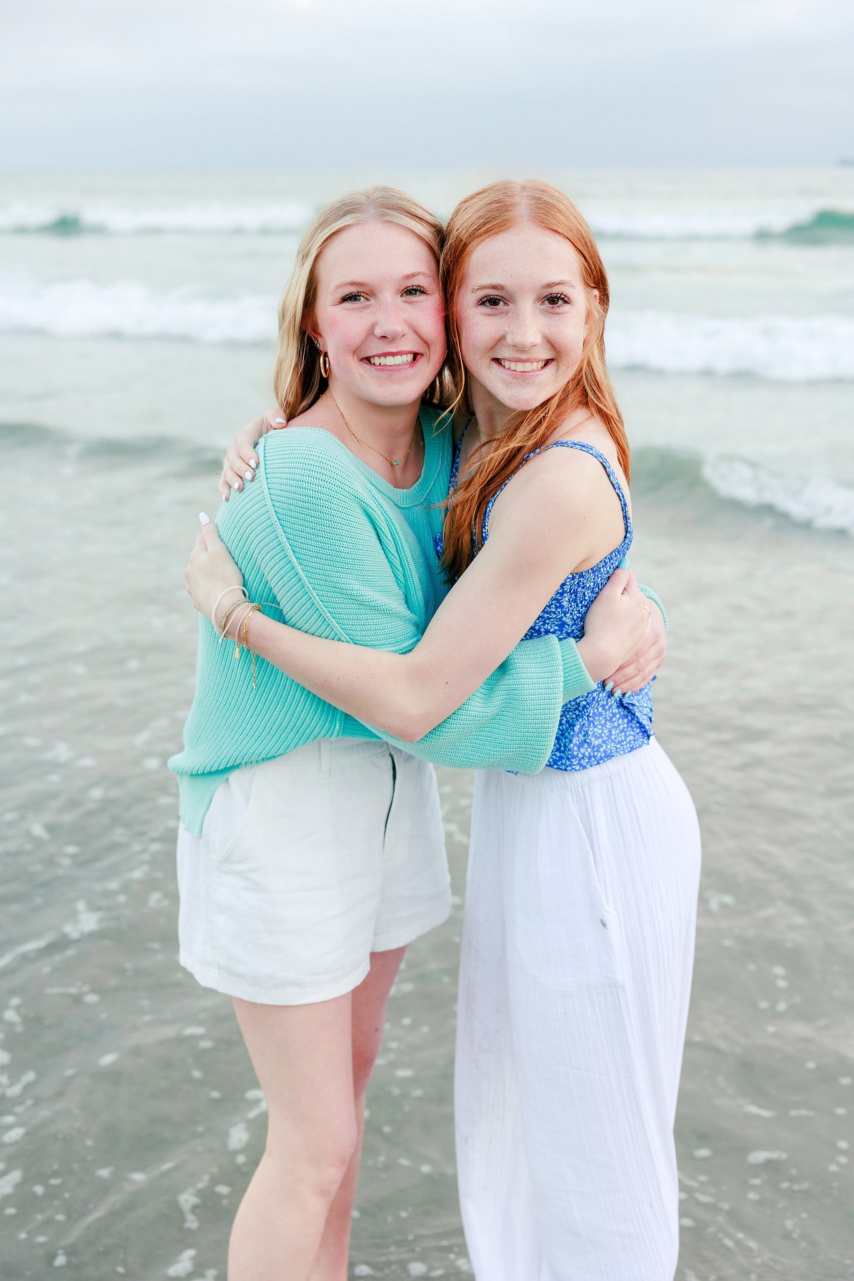 Sisters & Senior Portraits at the Del — 34 Two sisters from behind wading in shallow water, looking out at ocean waves