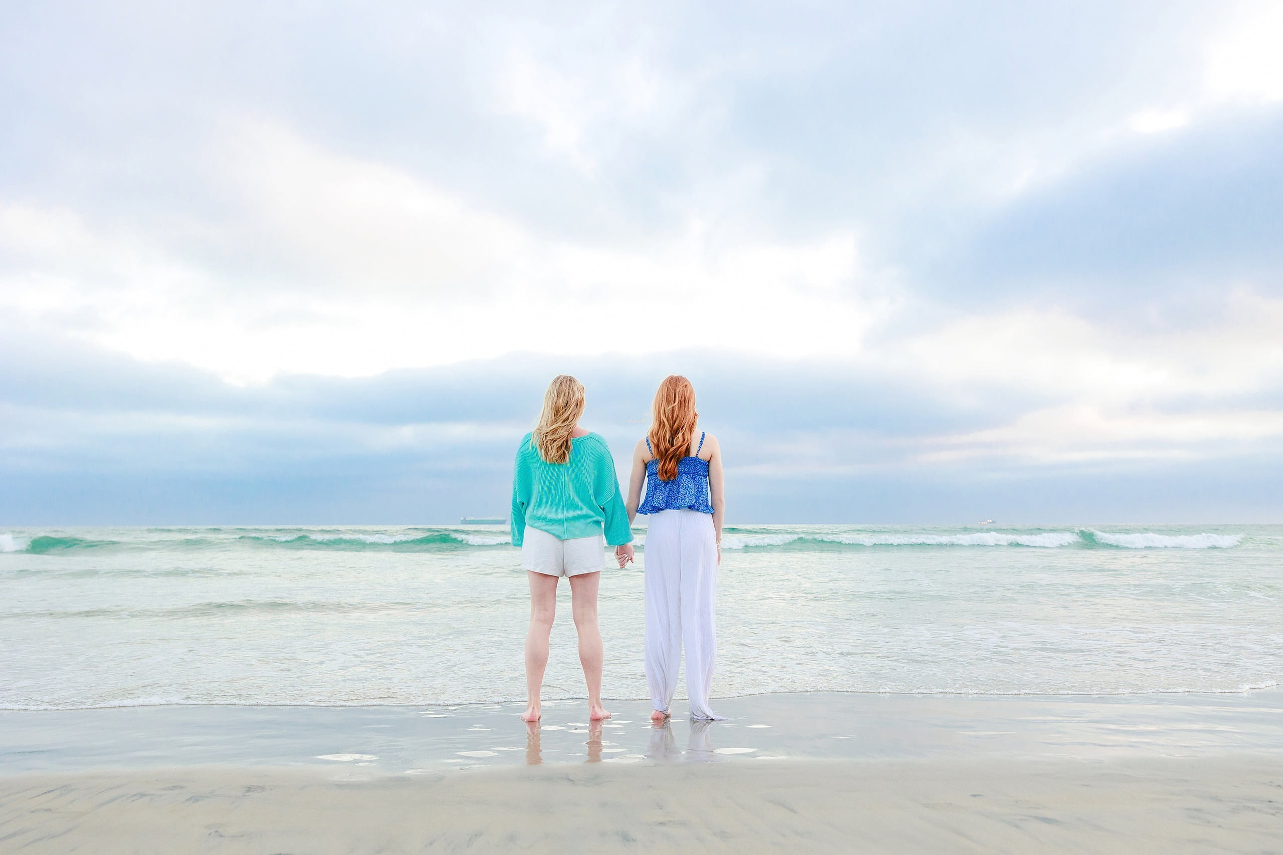 Sisters & Senior Portraits at the Del — 35 Teen in green tank top posing with hand on weathered rocky jetty