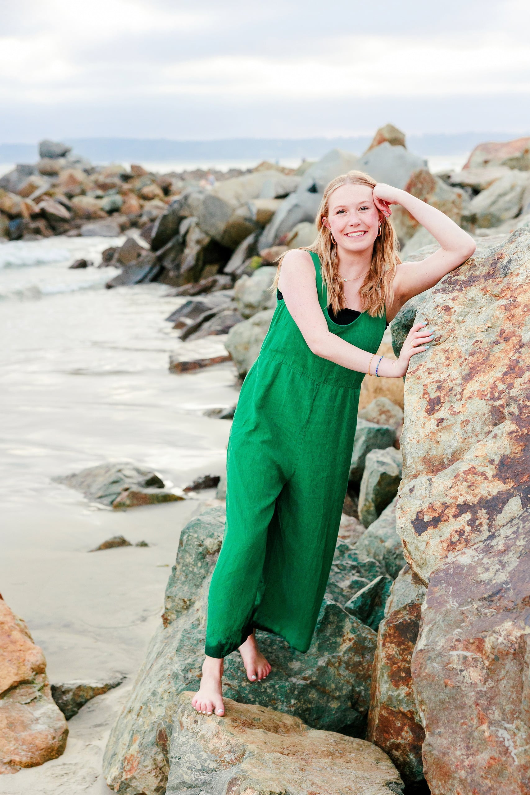 Sisters & Senior Portraits at the Del — 38 Ashlyn in blue floral top and white pants on beach, hand in pocket