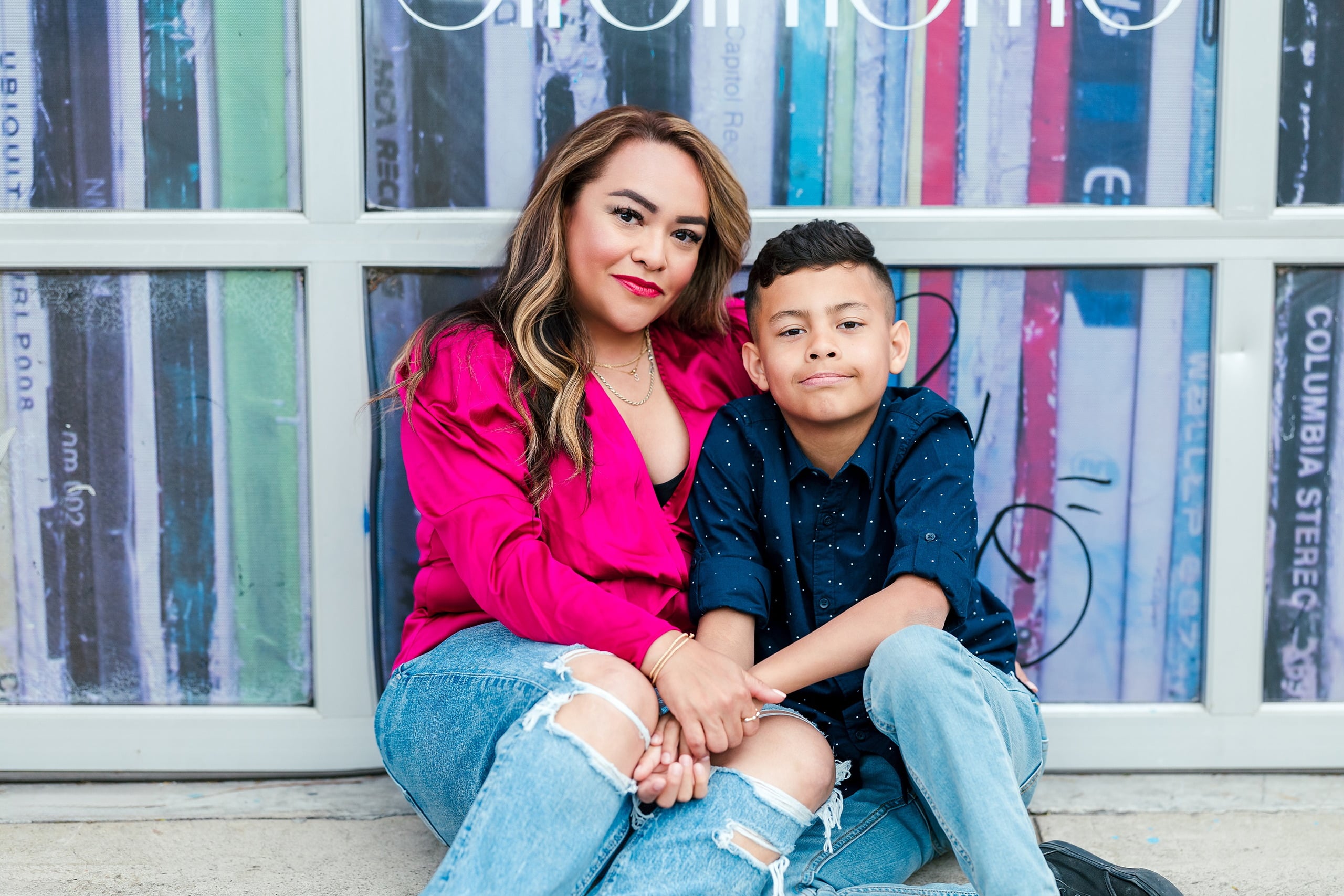 Spring Break Surprise: Why This Mom Booked a Secret Photo Session — 09 Woman and child sit together against Little Italy wall mural