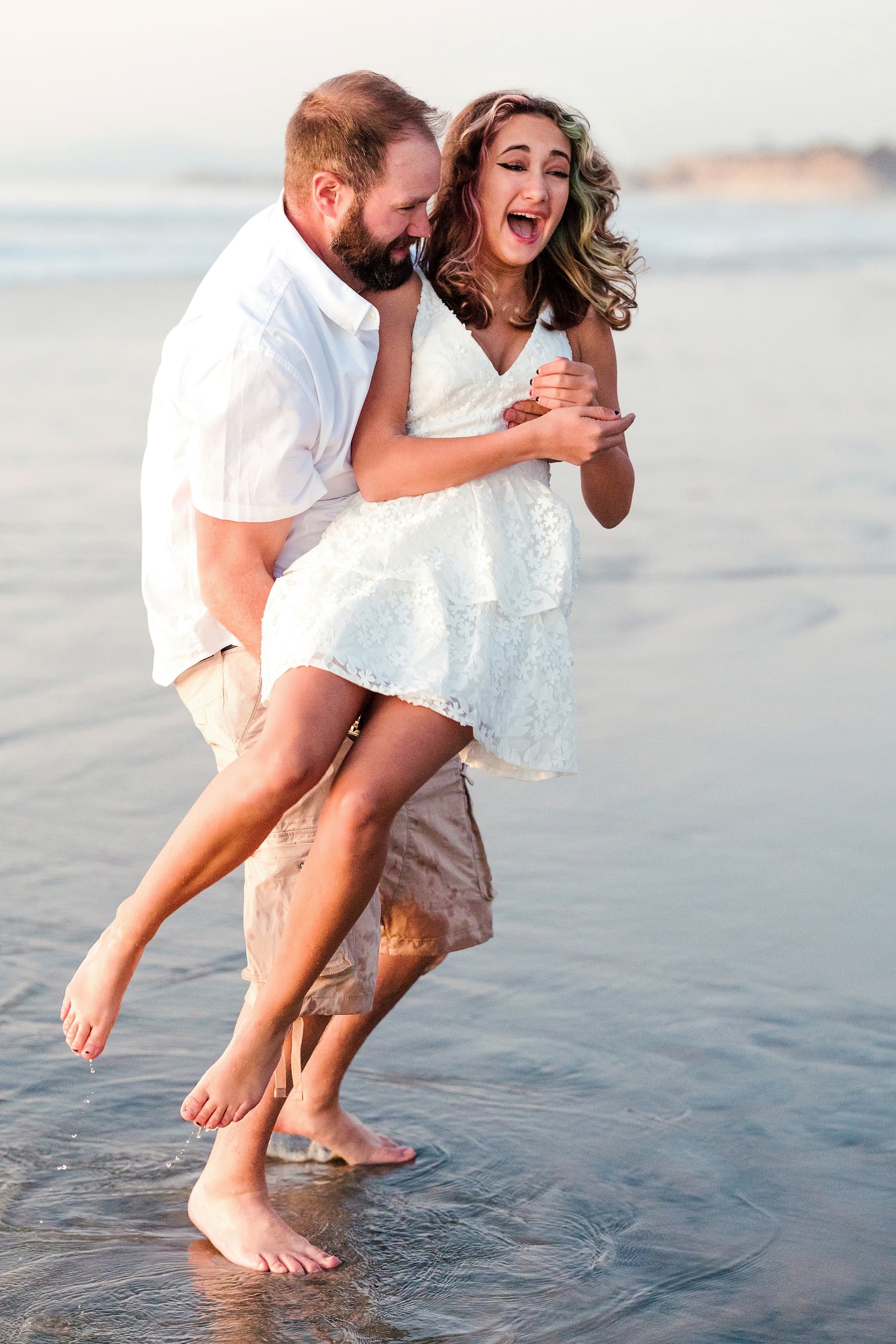 The Day the Sun Stood Still — 03 Couple embracing playfully in shallow ocean water at golden hour at Del Mar