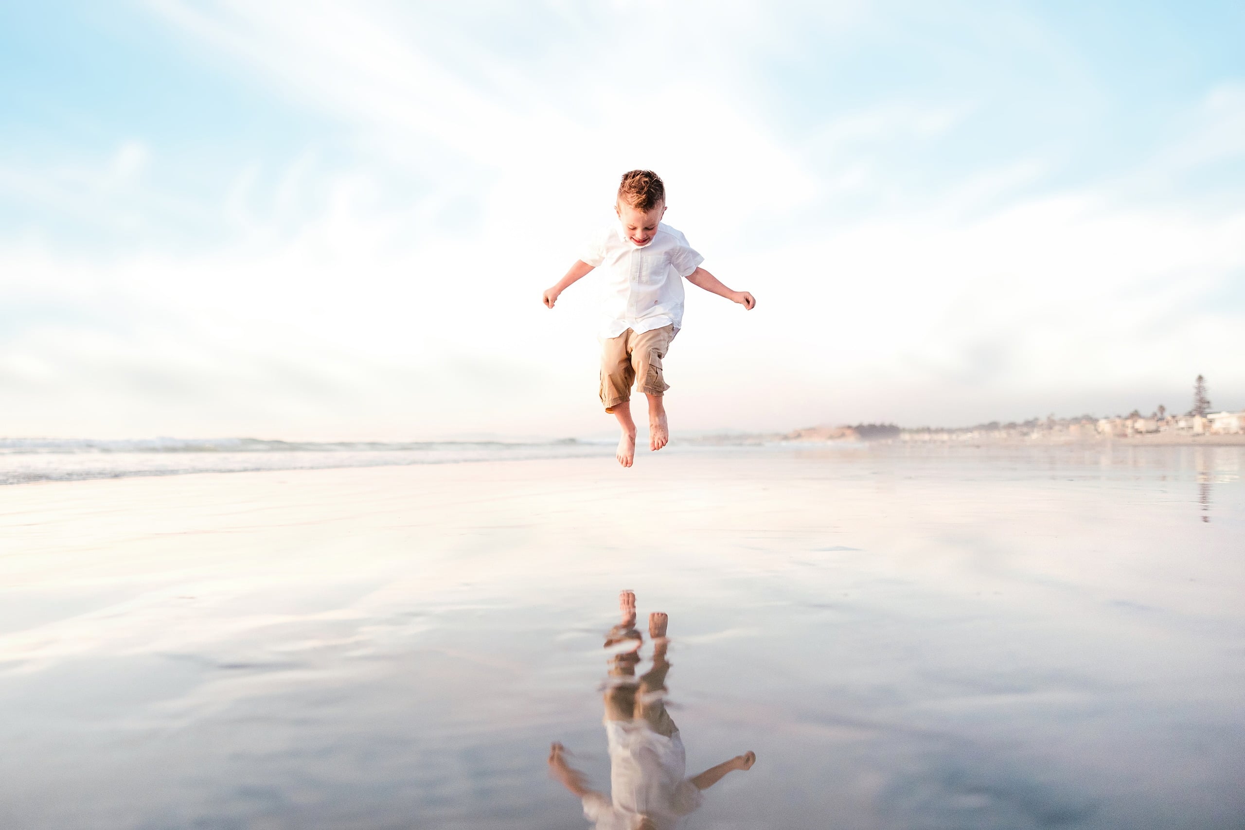 The Day the Sun Stood Still — 07 Child running with arms spread wide on wet beach sand at Del Mar