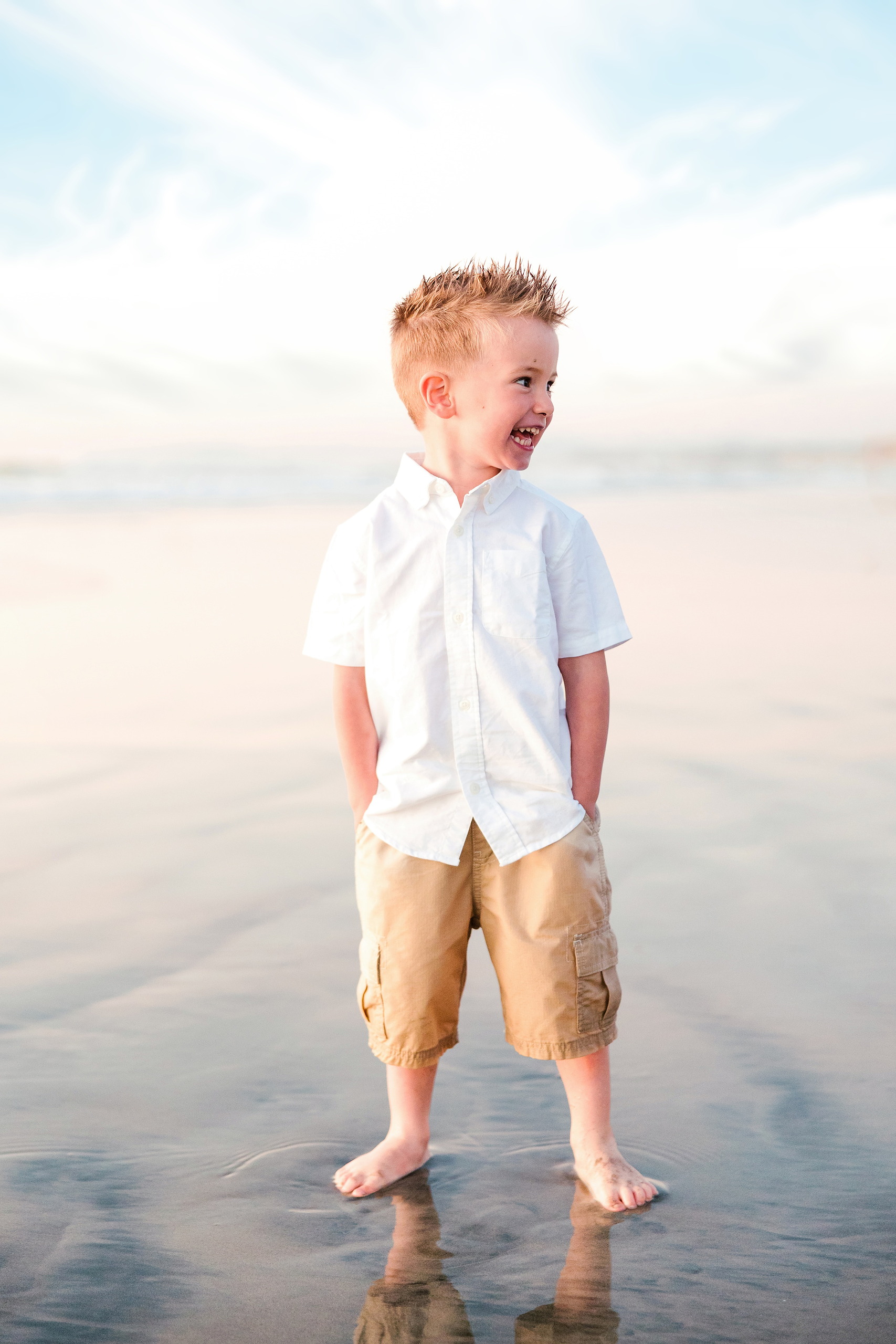 The Day the Sun Stood Still — 12 Boy in white shirt and tan shorts standing on wet beach sand at golden hour