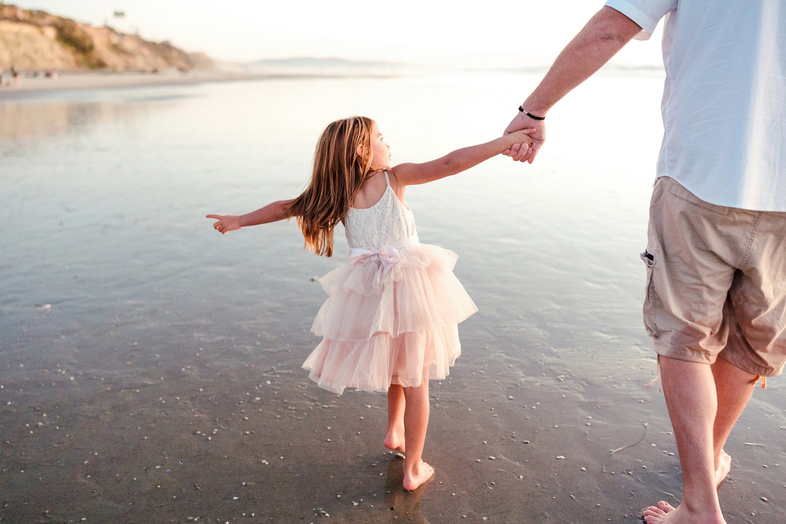 The Day the Sun Stood Still — 13 Woman and young child hand-in-hand walking on wet beach sand at sunset
