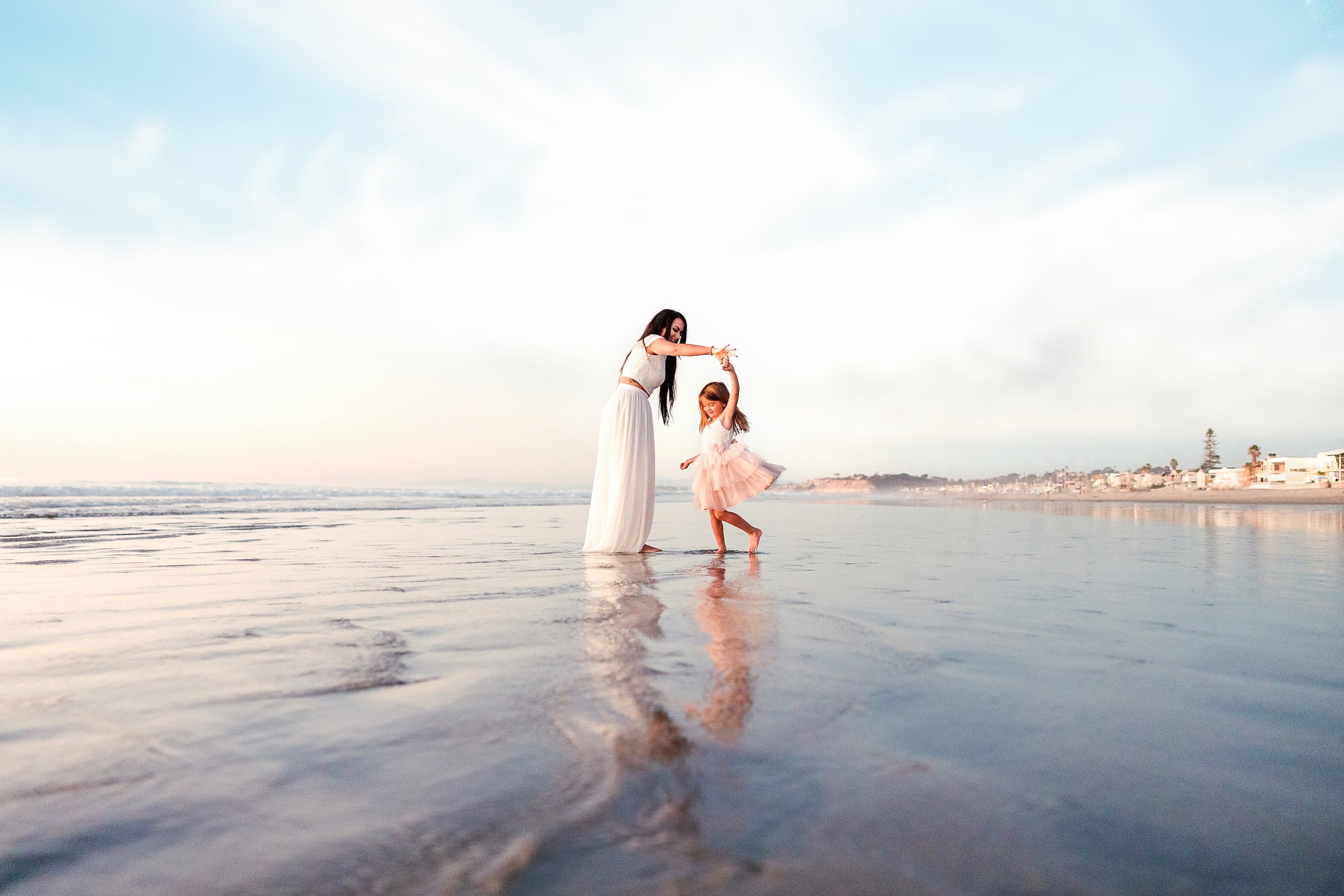 The Day the Sun Stood Still — 15 Woman and child dancing together on wet beach sand at golden hour at Del Mar