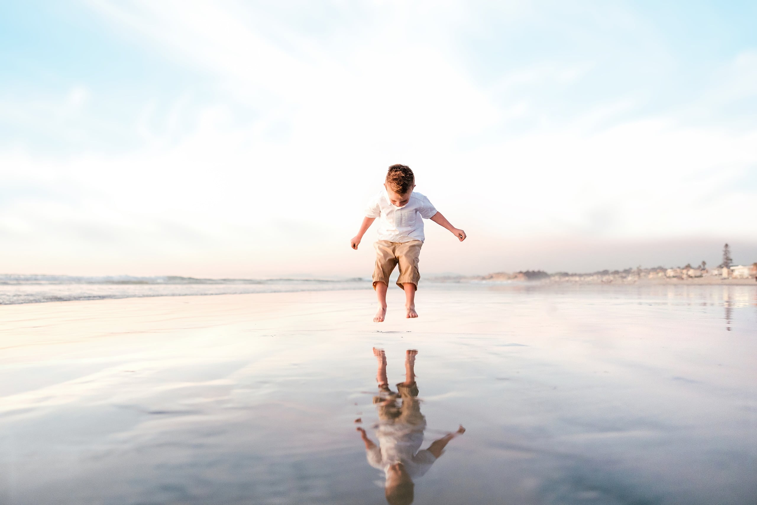 The Day the Sun Stood Still — 19 Child running with open arms across wet beach sand at golden hour at Del Mar