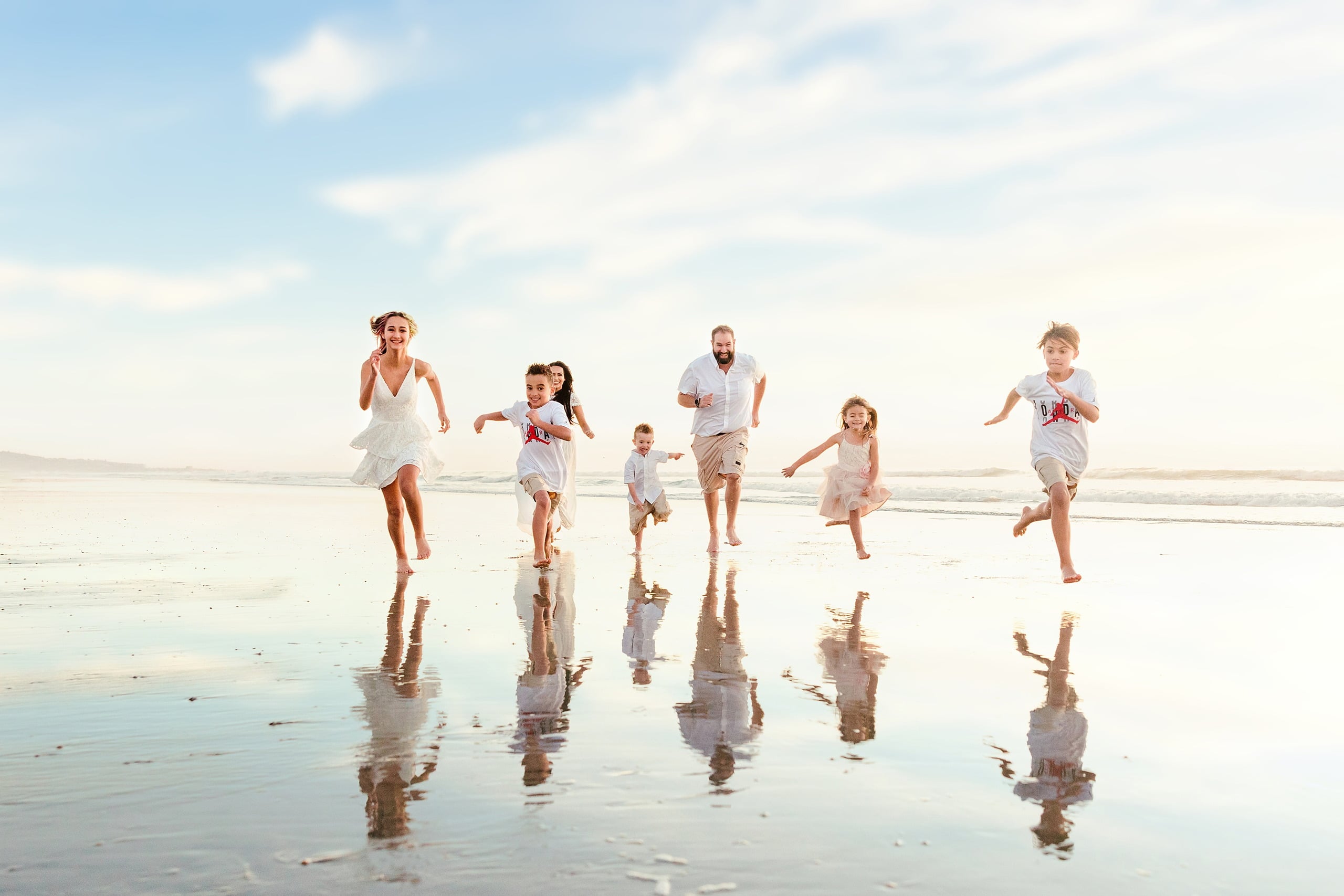 The Day the Sun Stood Still — 24 Family of seven running together across wet beach sand at Del Mar