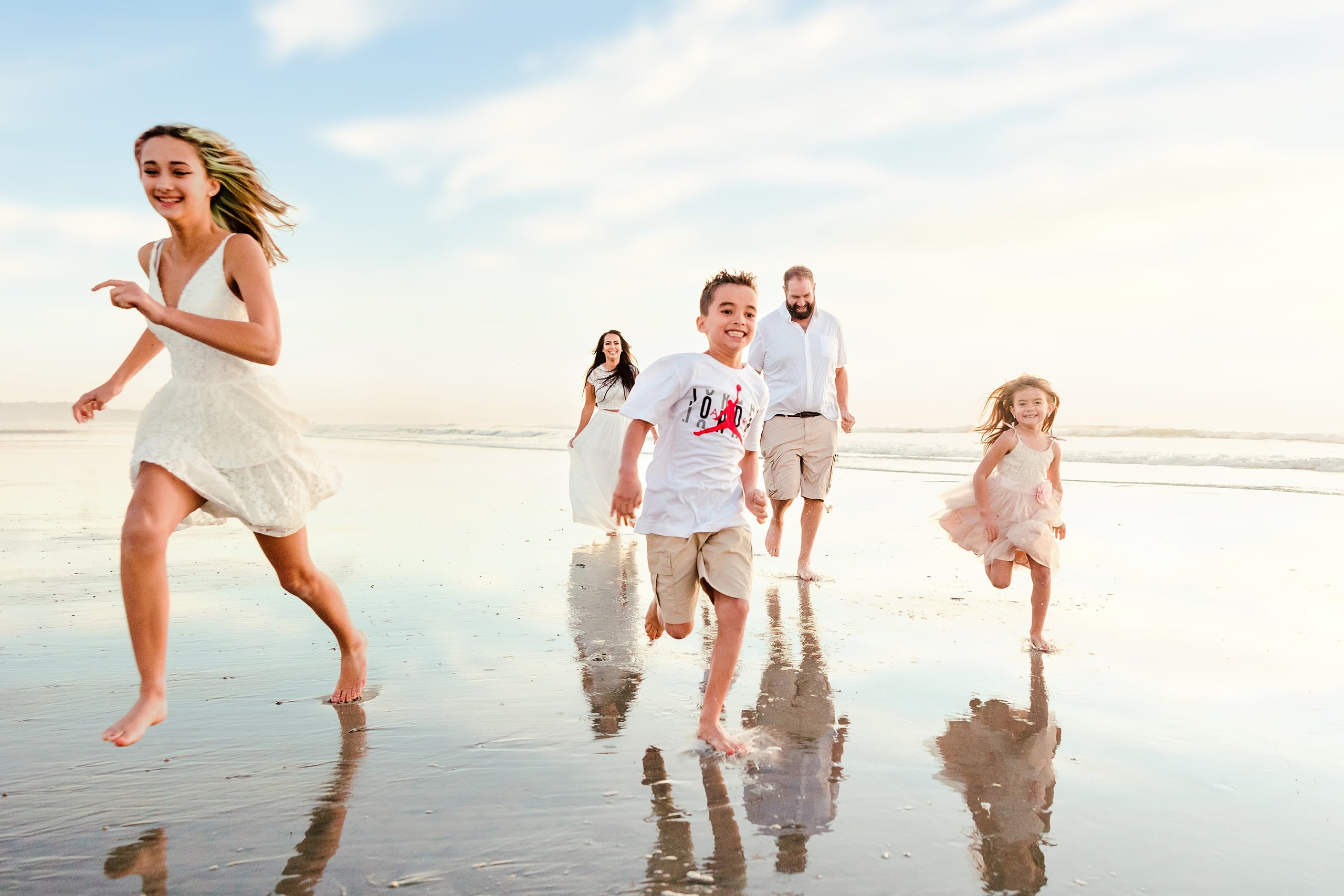 The Day the Sun Stood Still — 25 Teenage girl in white dress running with family in background on beach