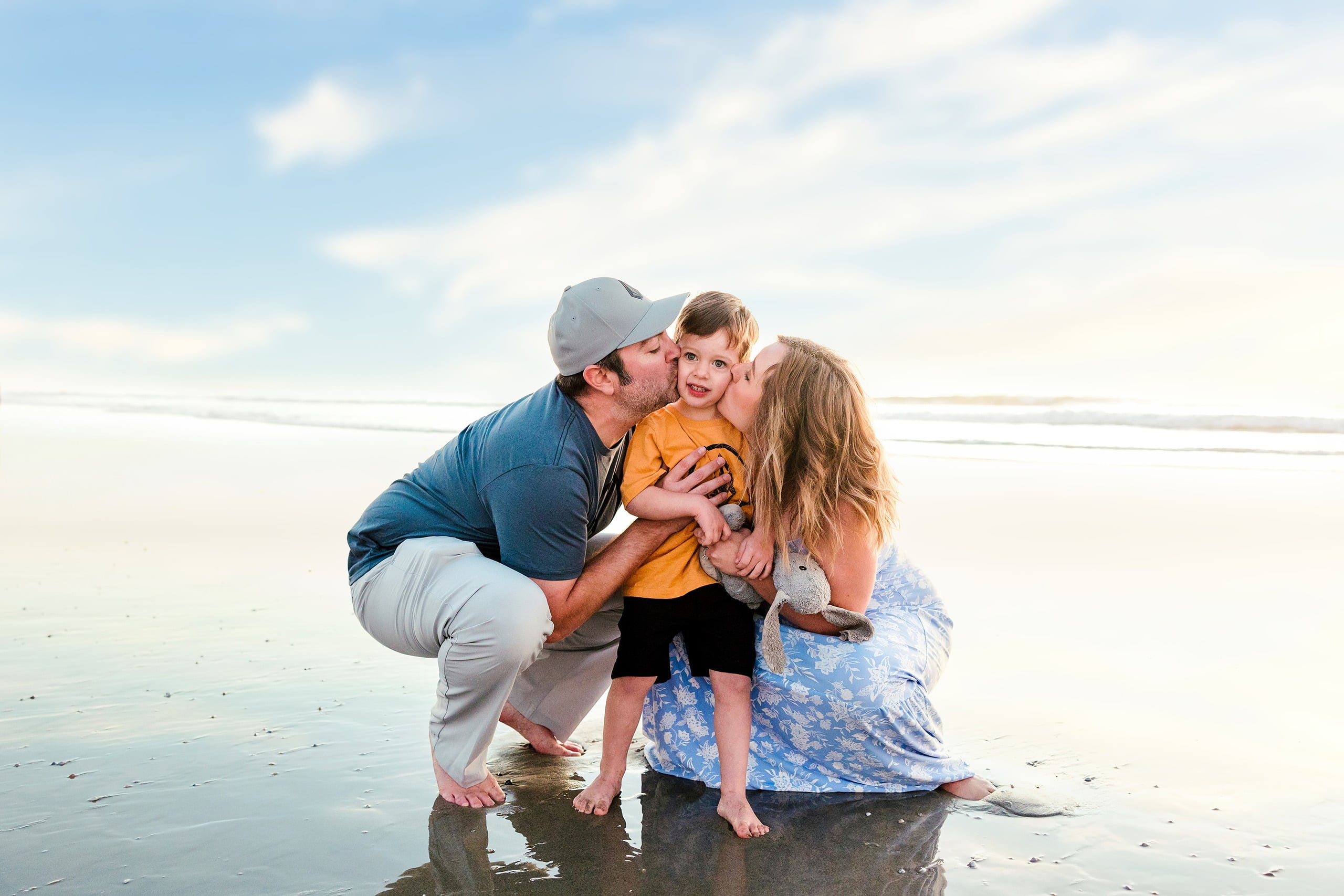 The Day the Sun Stood Still — 29 Man holding and smiling with two young children on wet beach sand at Del Mar