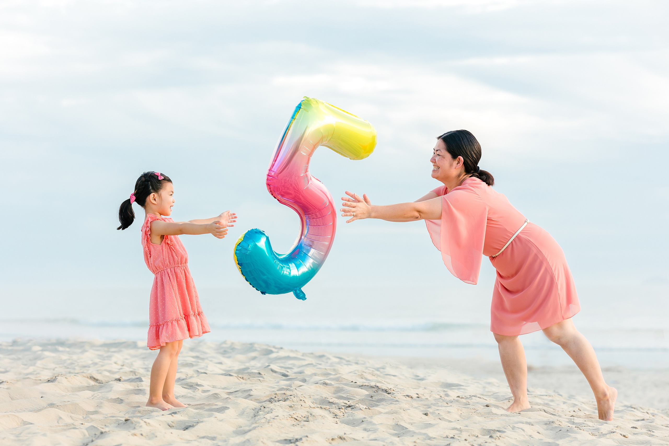 Turning Five on Coronado — 03 Ava and mom playing together with her oversized birthday balloon on beach