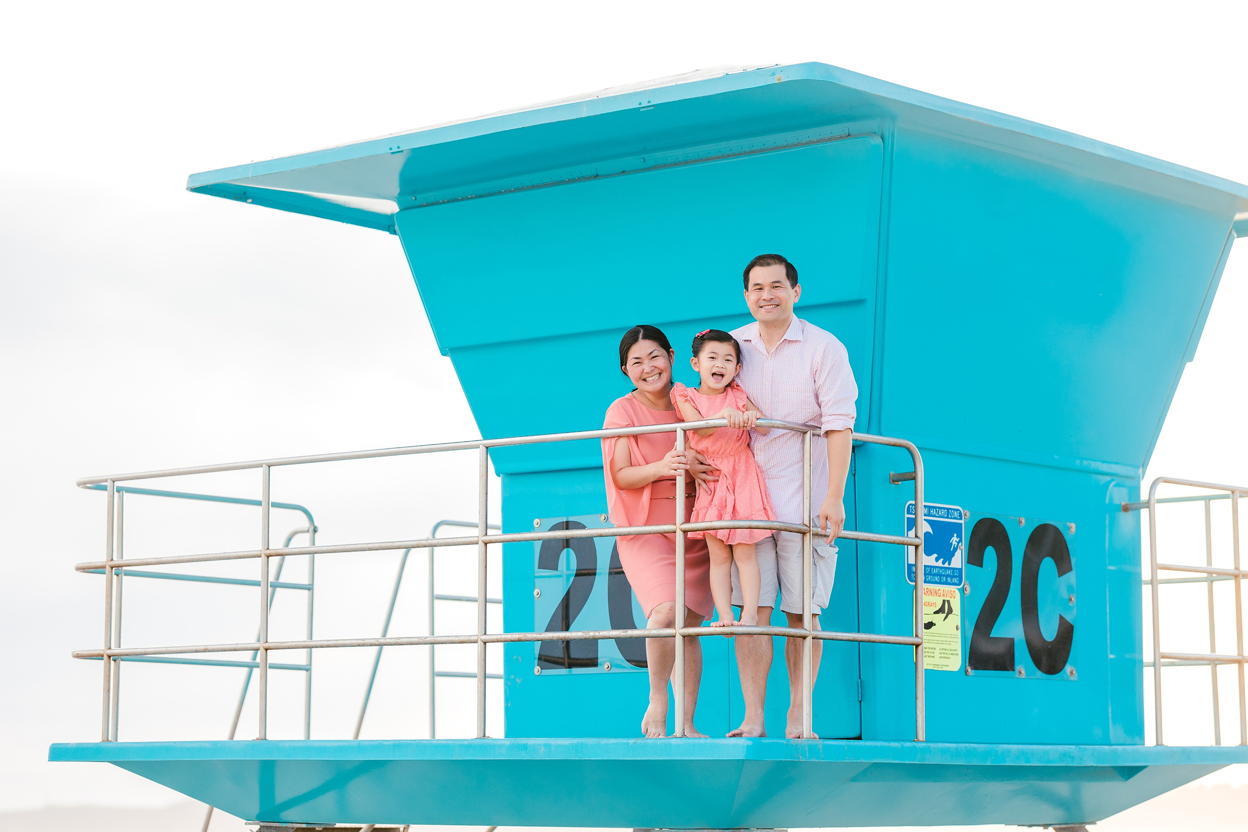Turning Five on Coronado — 09 Ava and her parents posing together at the iconic turquoise lifeguard tower