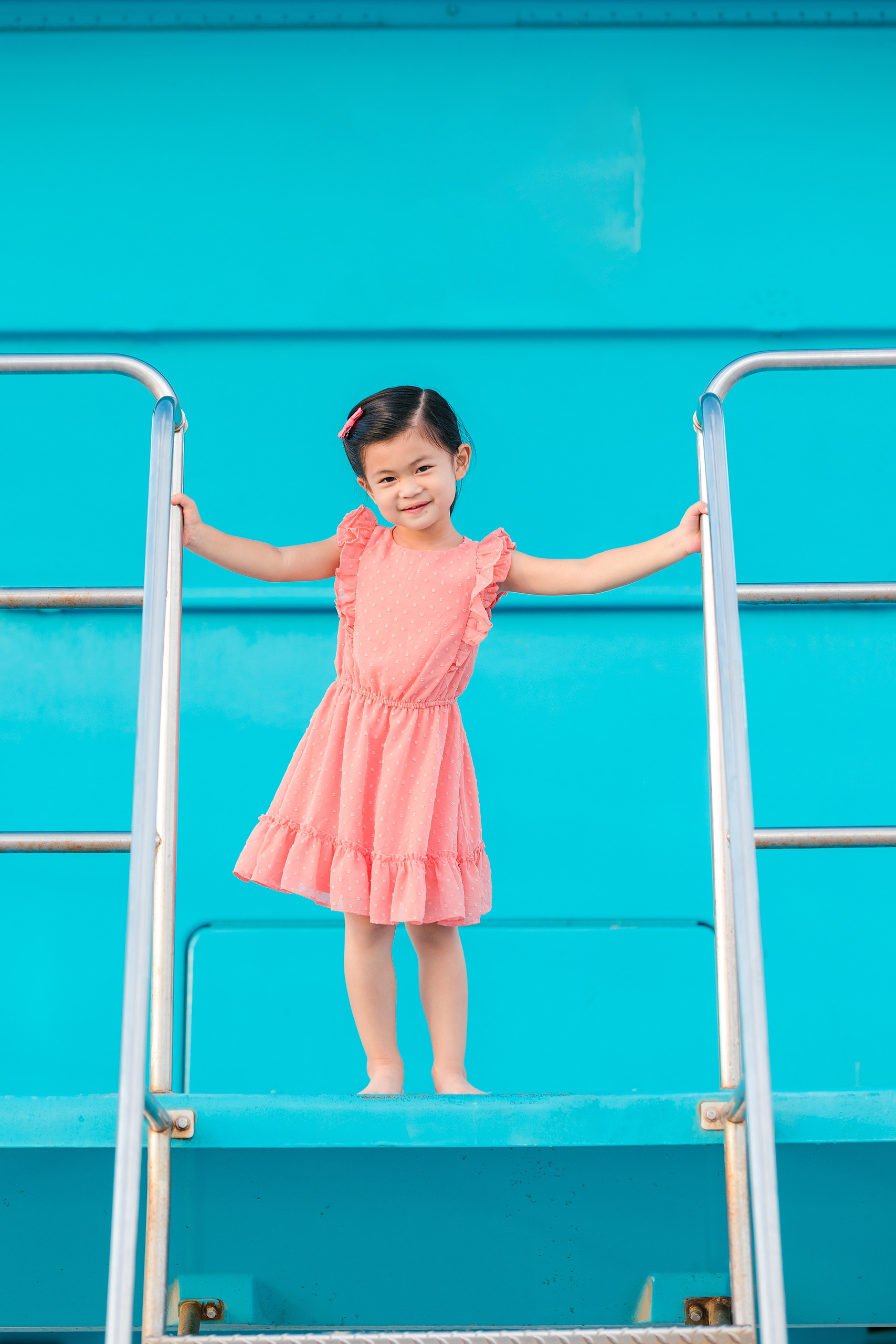 Turning Five on Coronado — 11 Ava standing on the lifeguard tower with arms outstretched at Coronado
