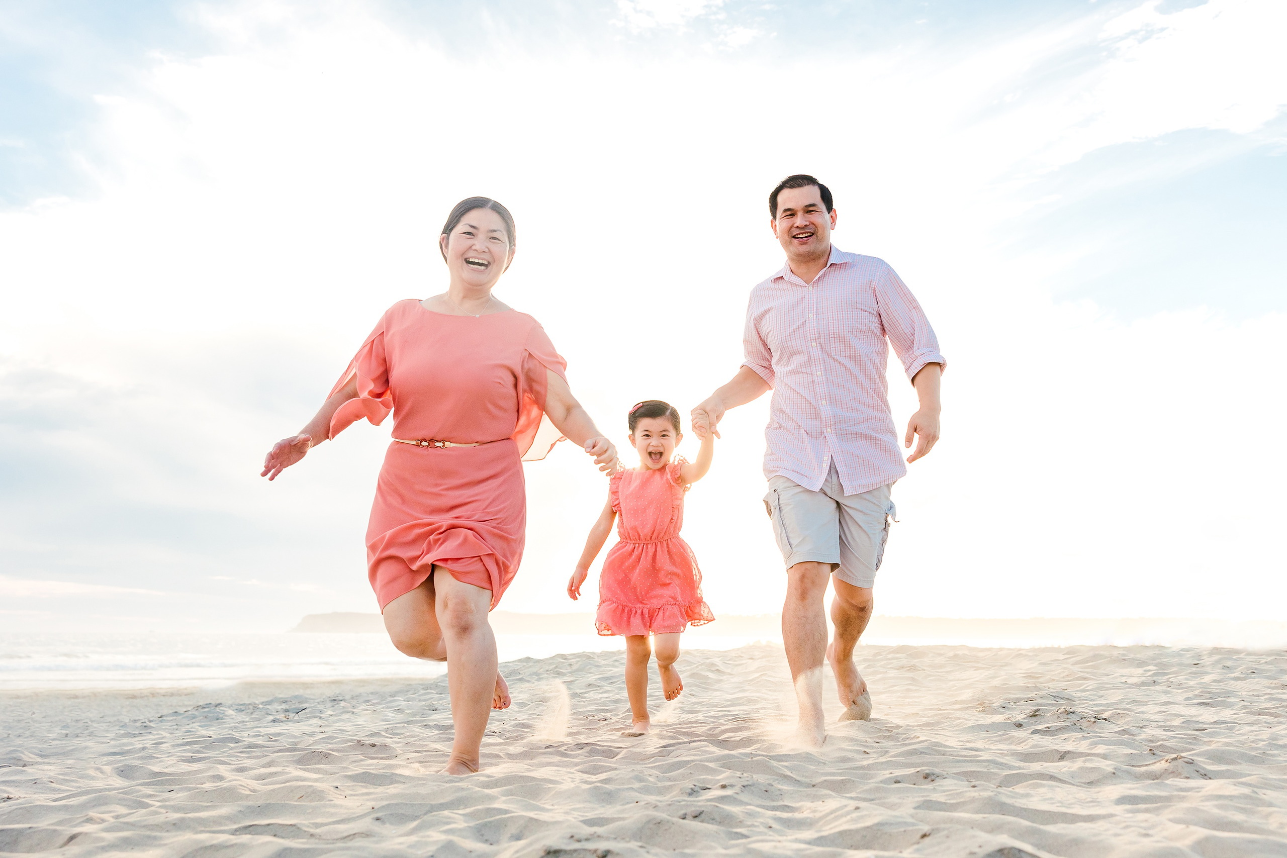 Turning Five on Coronado — 12 Ava and her parents running together playfully across sand at golden hour