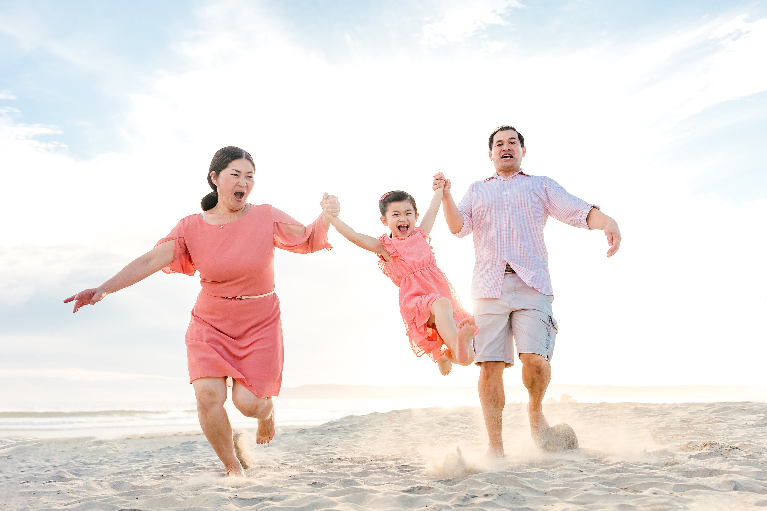 Turning Five on Coronado — 13 Ava's parents running with her on beach, both holding her hands joyfully
