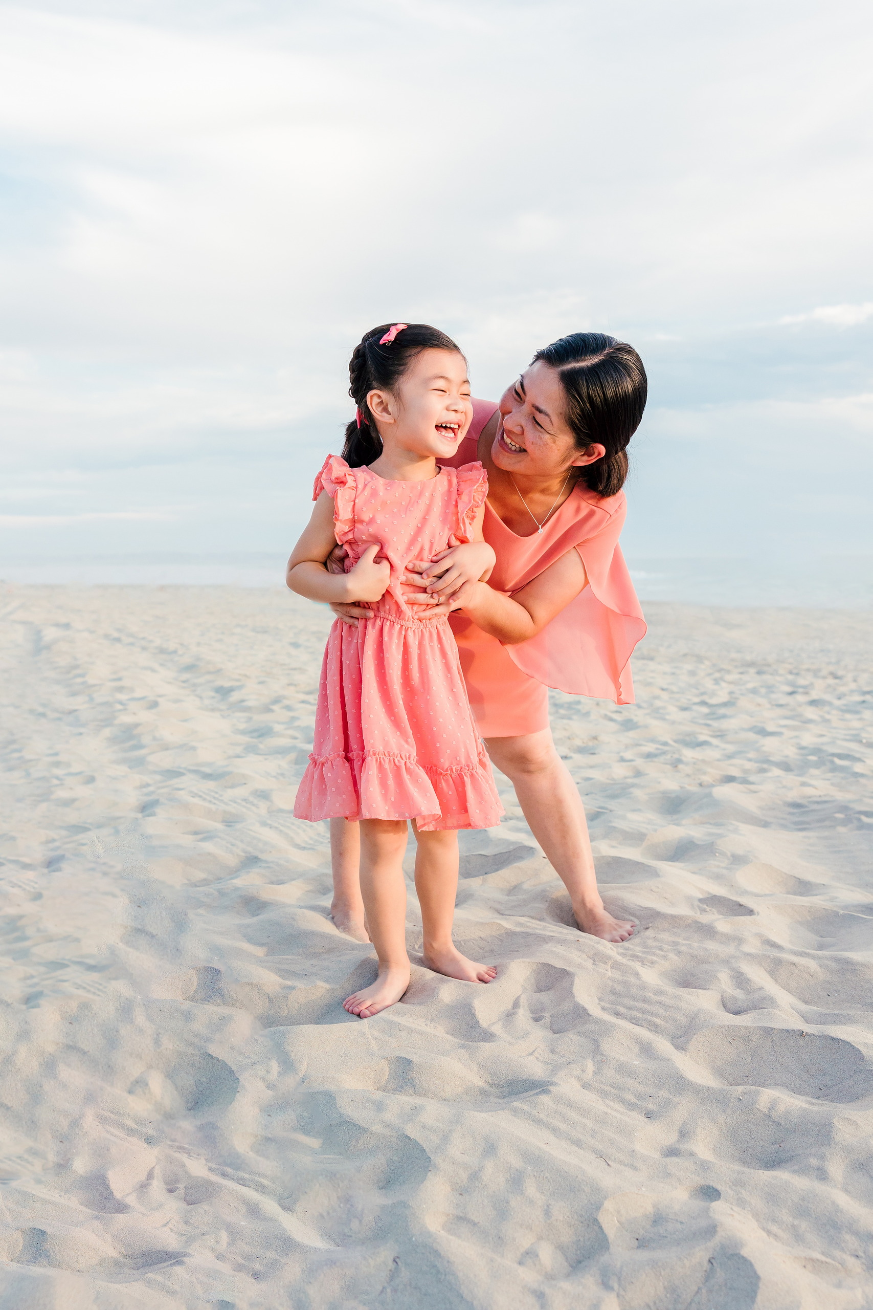 Turning Five on Coronado — 16 Mom hugging and playing joyfully with Ava on the sandy beach area