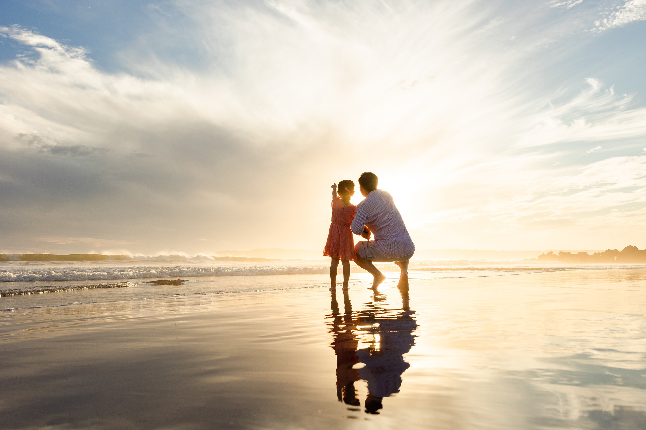 Turning Five on Coronado — 17 Ava standing with dad on wet sand at sunset near the shore at Coronado