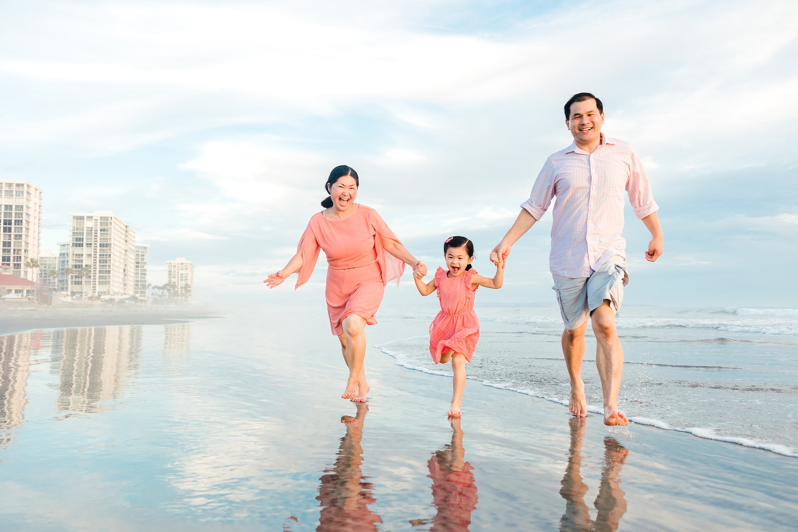 Turning Five on Coronado — 20 Family of three running in shallow water with hotel in background