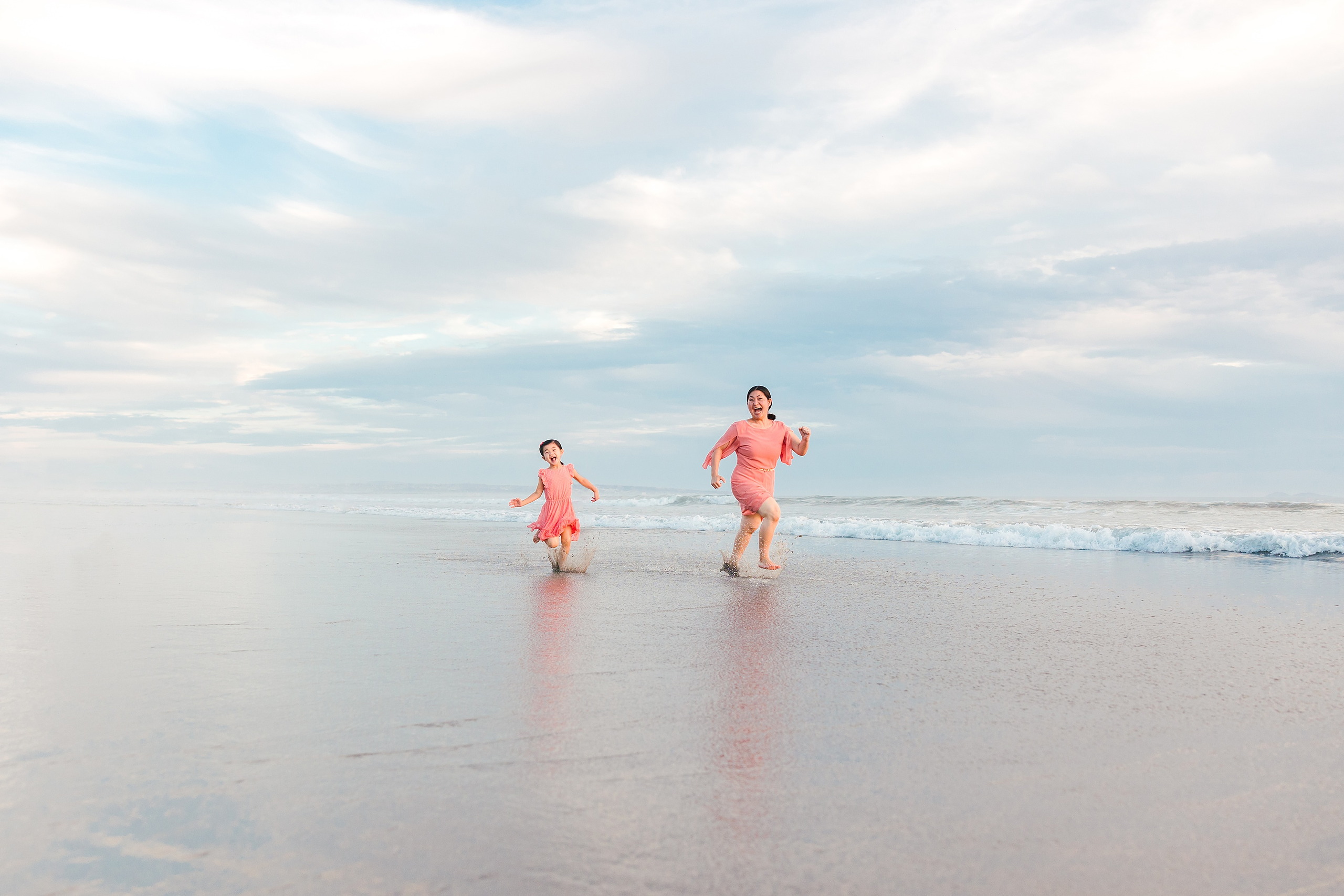 Turning Five on Coronado — 21 Ava running with her parents in shallow beach water at golden hour