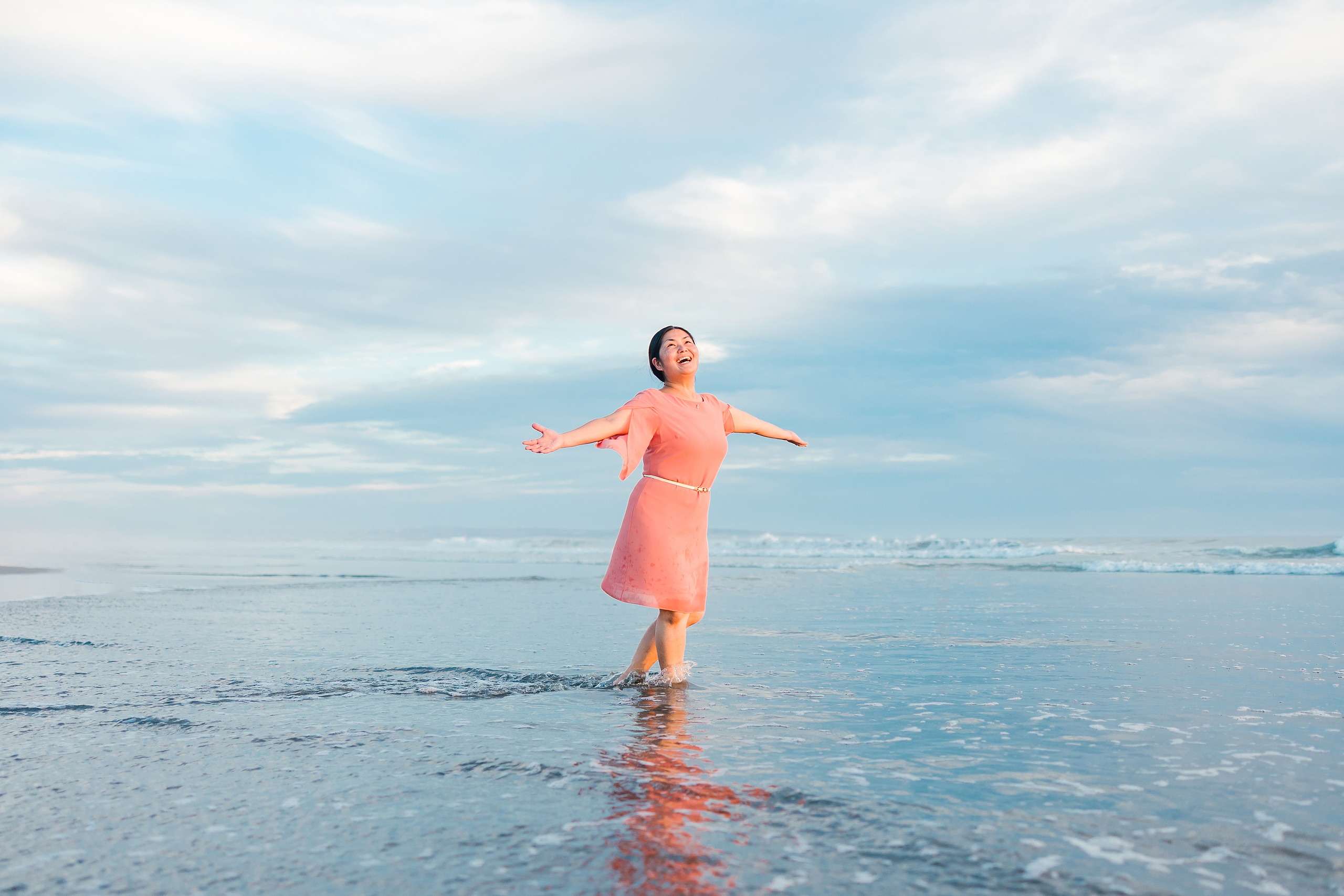 Turning Five on Coronado — 22 Ava standing in shallow water with arms spread wide open happily