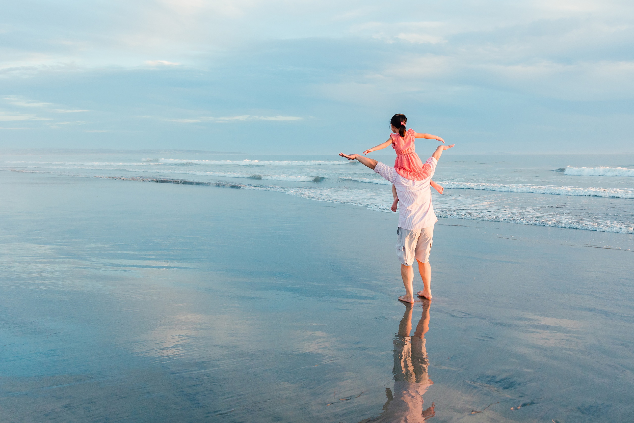 Turning Five on Coronado — 24 Ava being lifted high in the air in shallow beach water joyfully