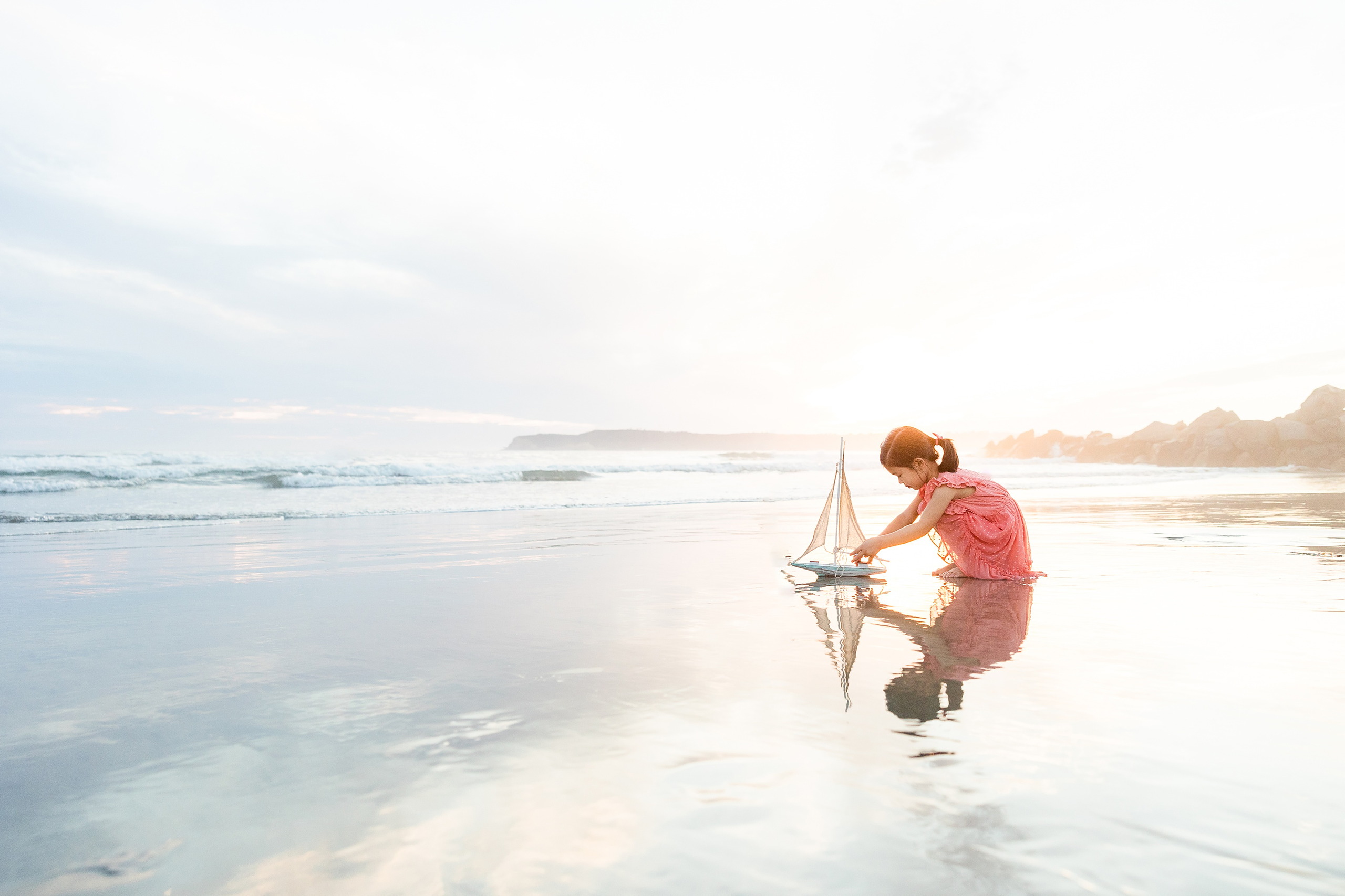 Turning Five on Coronado — 31 Ava playing in shallow water at sunset with reflections in wet sand