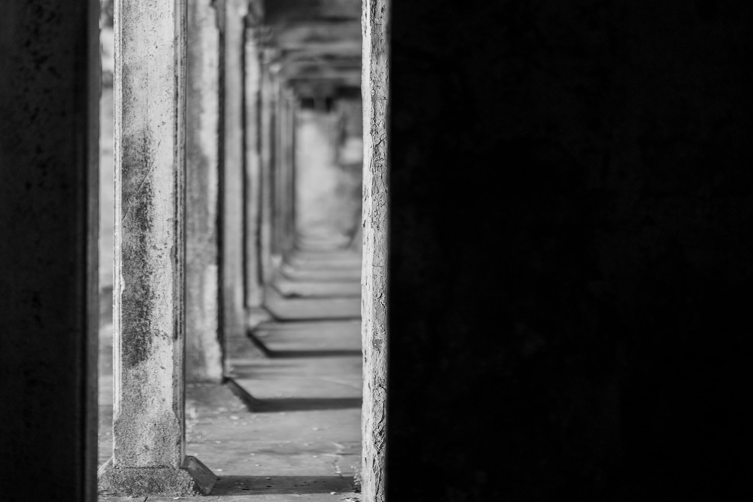 Zach’s Senior Portraits — 07 Receding perspective of concrete columns in tunnel, black and white