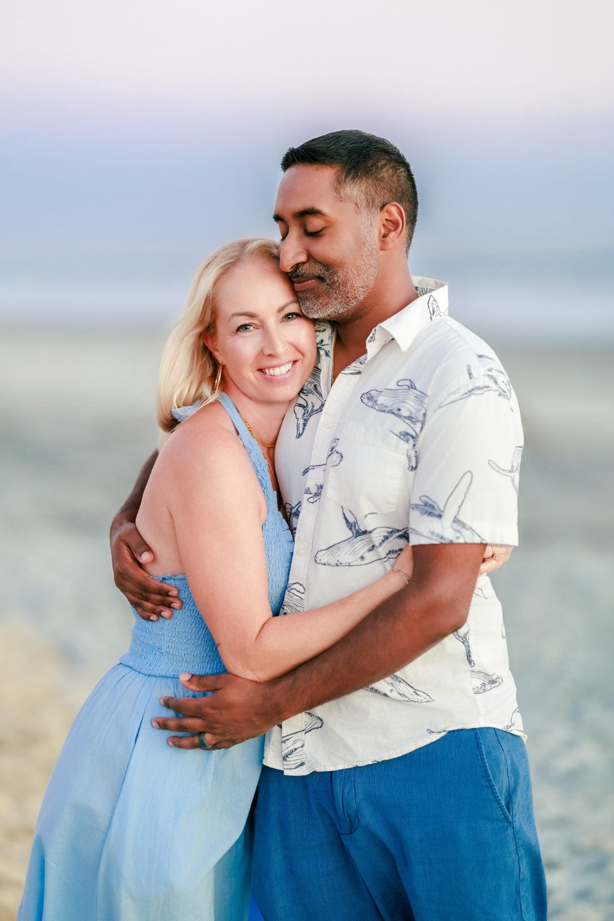 Couple embraces softly on Coronado Beach during golden hour portrait session