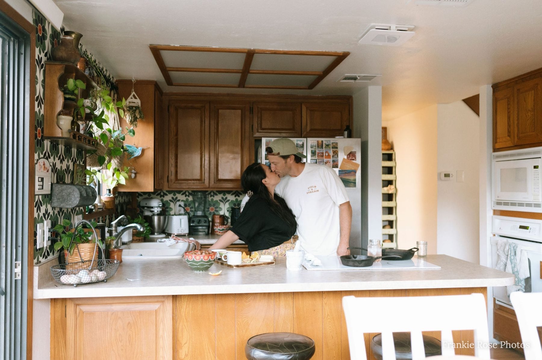 Couple shares a kiss while cooking together in their Lakeside kitchen