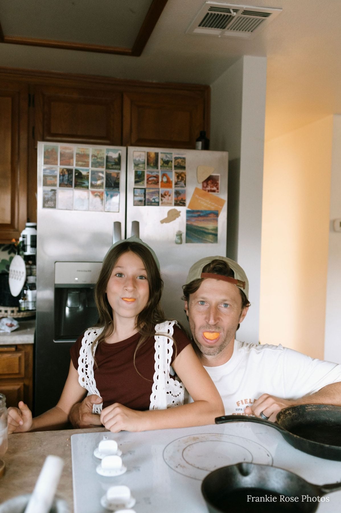 Couple laughing together in a rustic kitchen with fridge photos