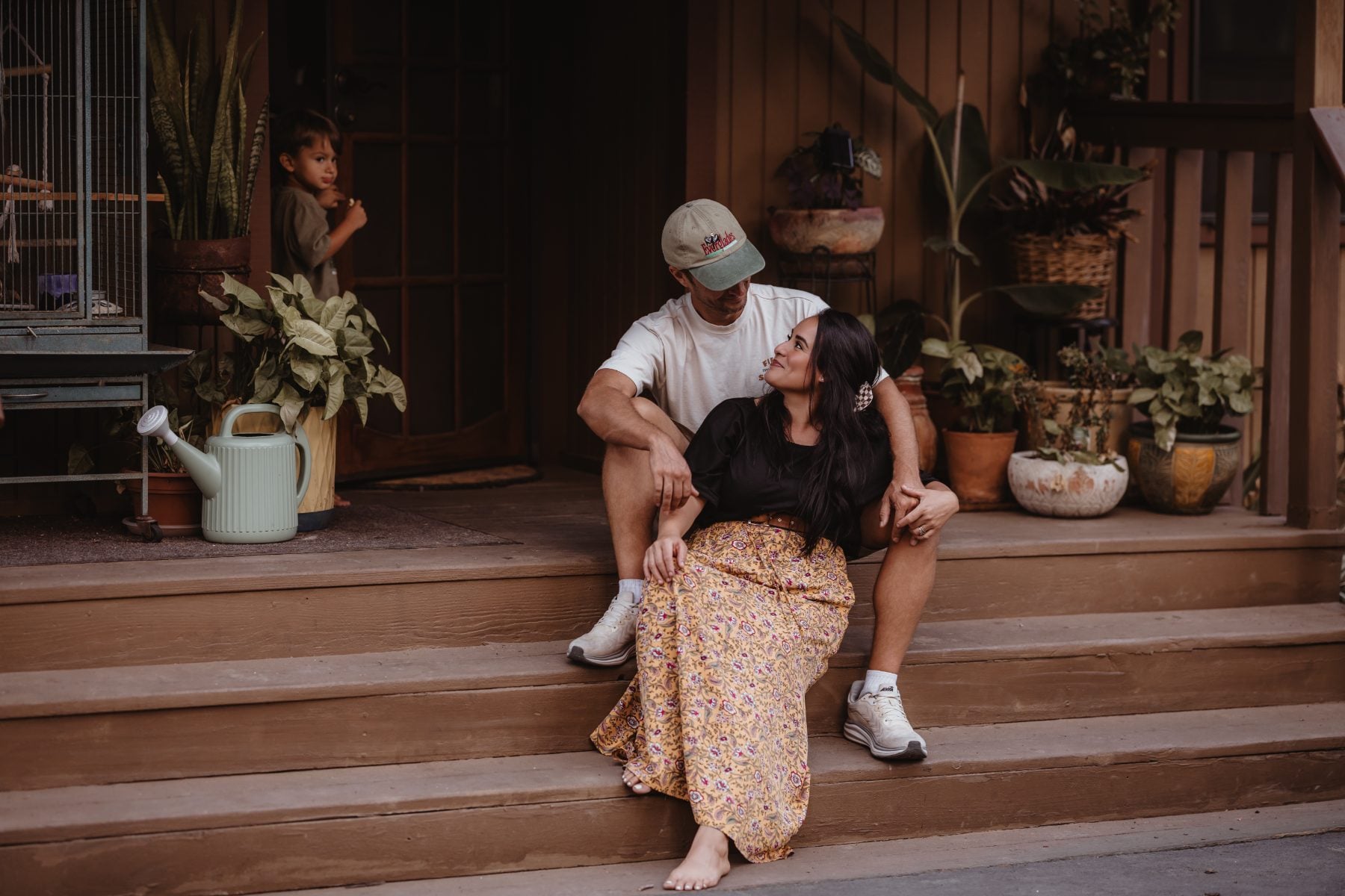 Couple sharing a laugh on the front porch steps at their Lakeside home