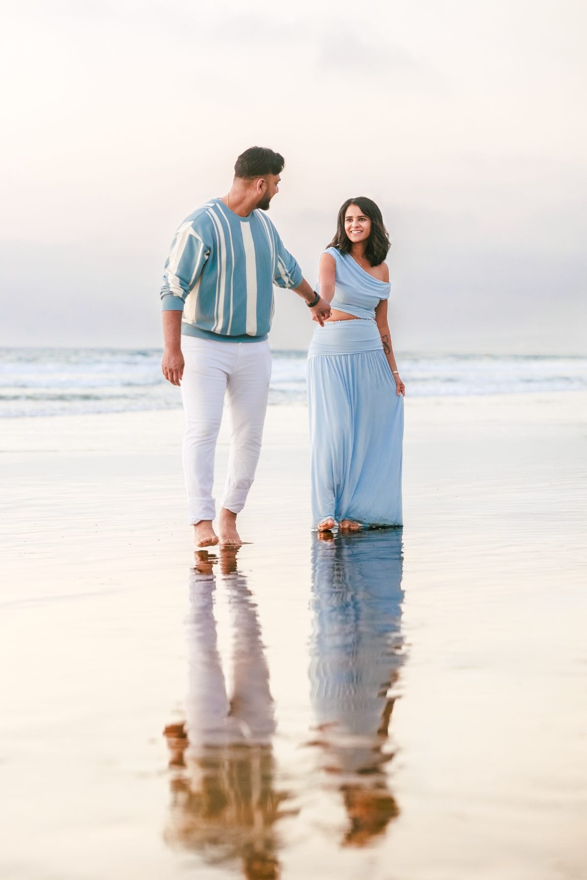 Couple strolls hand in hand along La Jolla Shores shoreline
