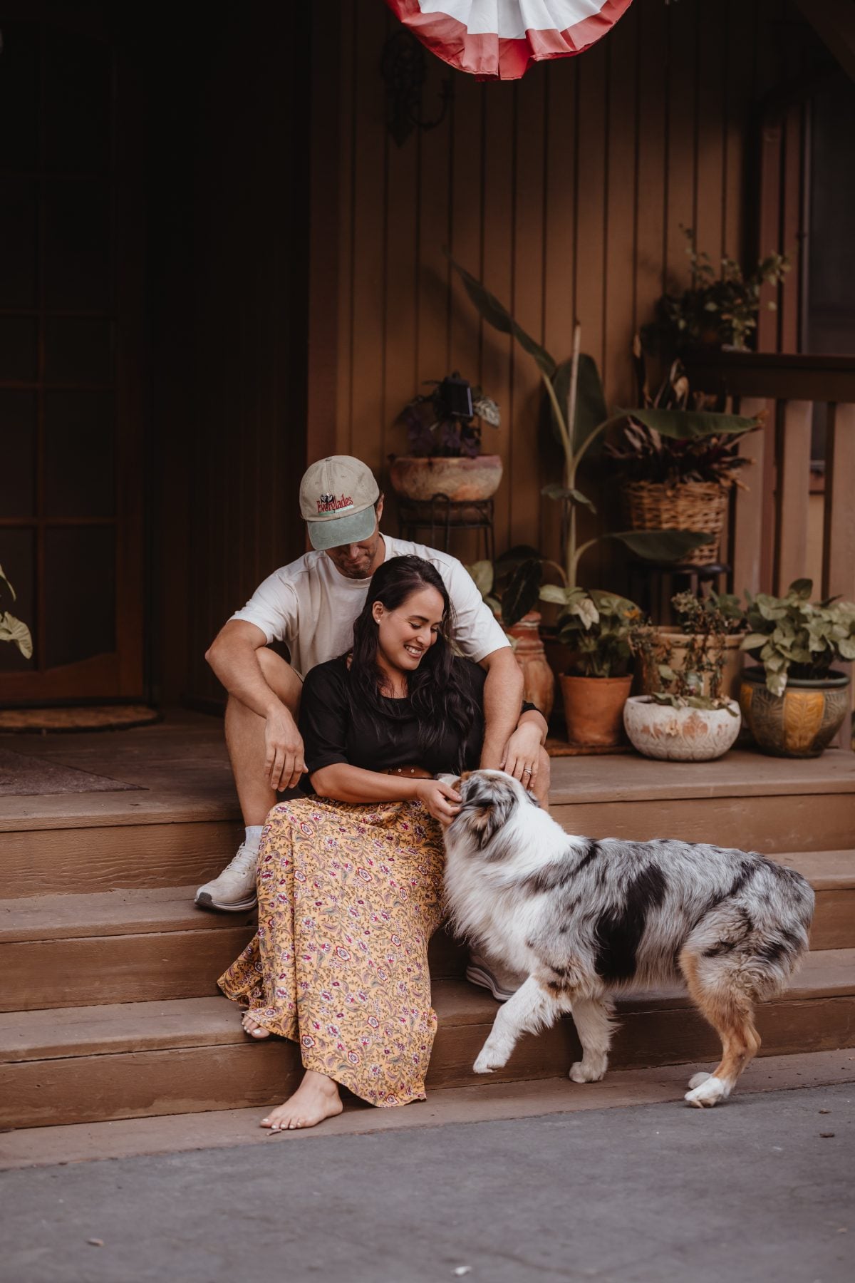 Couple bonding with their dog on porch steps in Lakeside