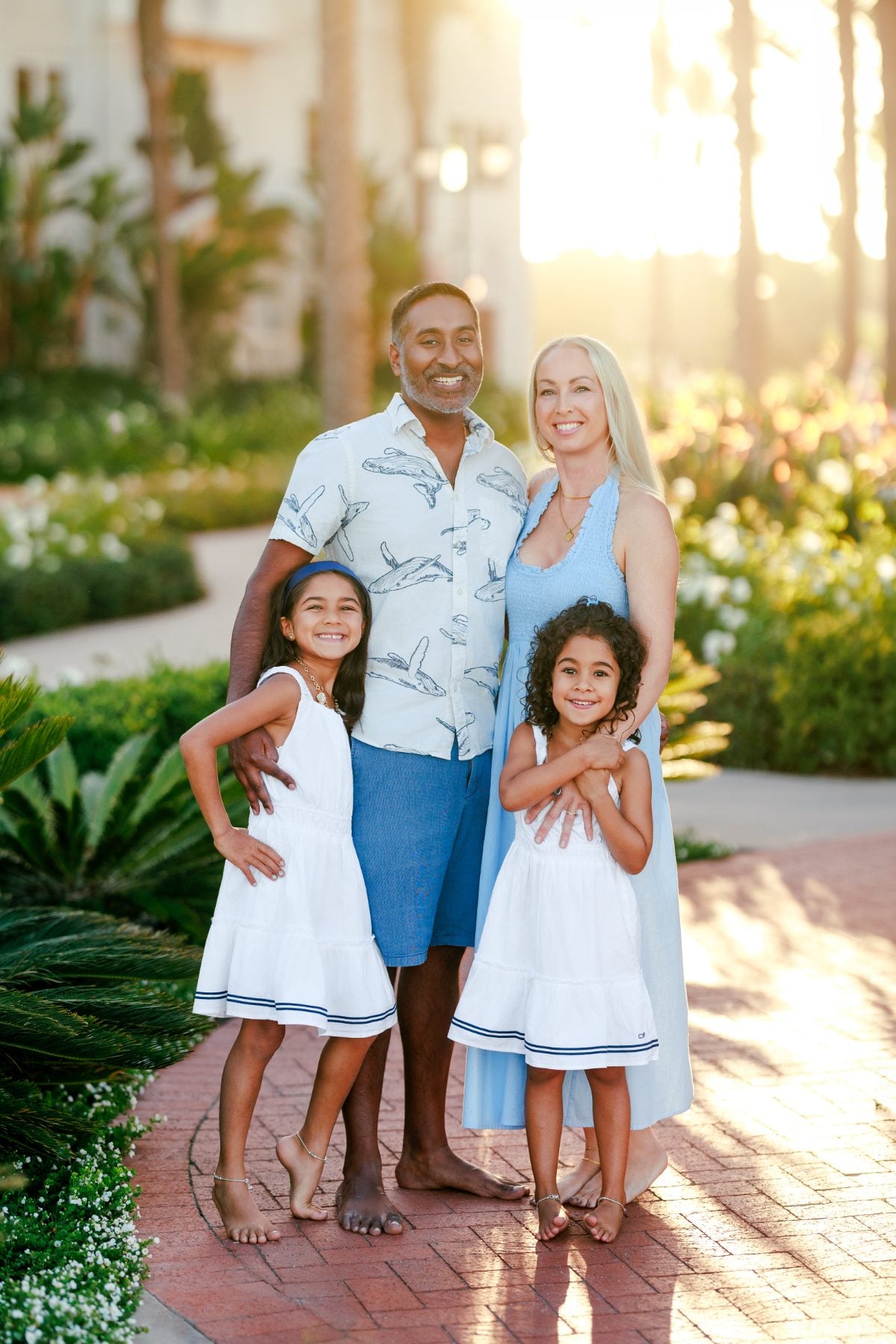 Extended family of four posing together in the Hotel del Coronado gardens