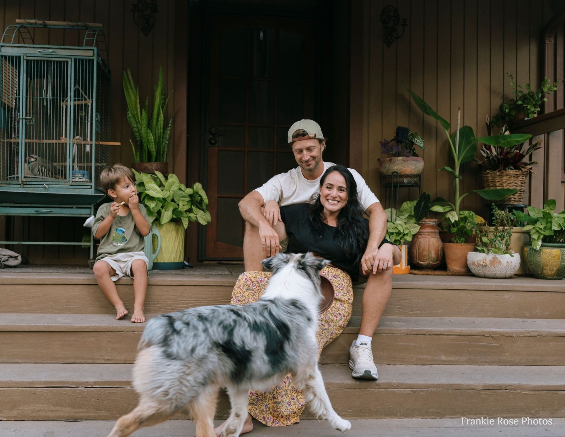 Family of three poses on porch steps with dog for extended family photographer