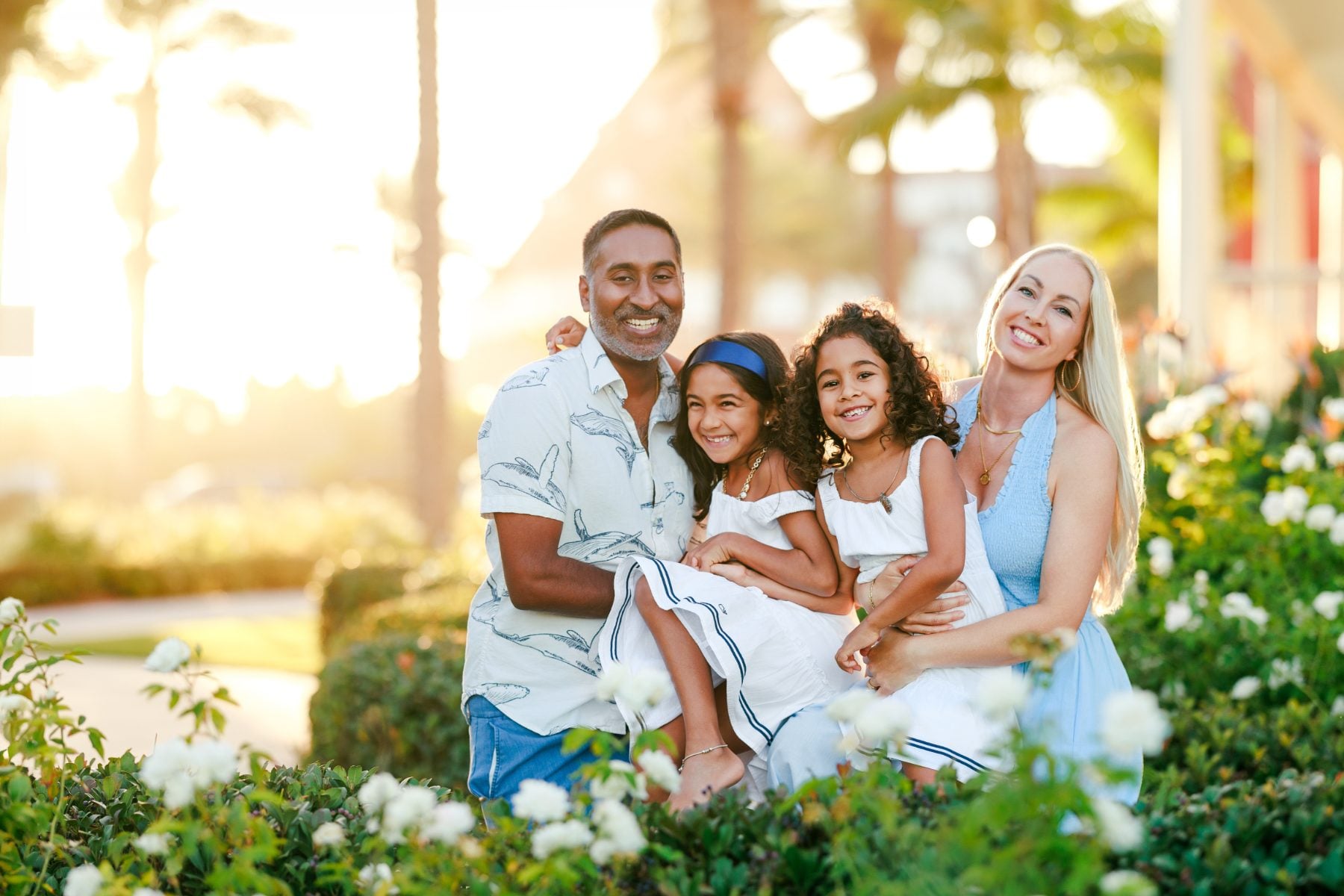 Family of four smiles together in garden at Hotel del Coronado